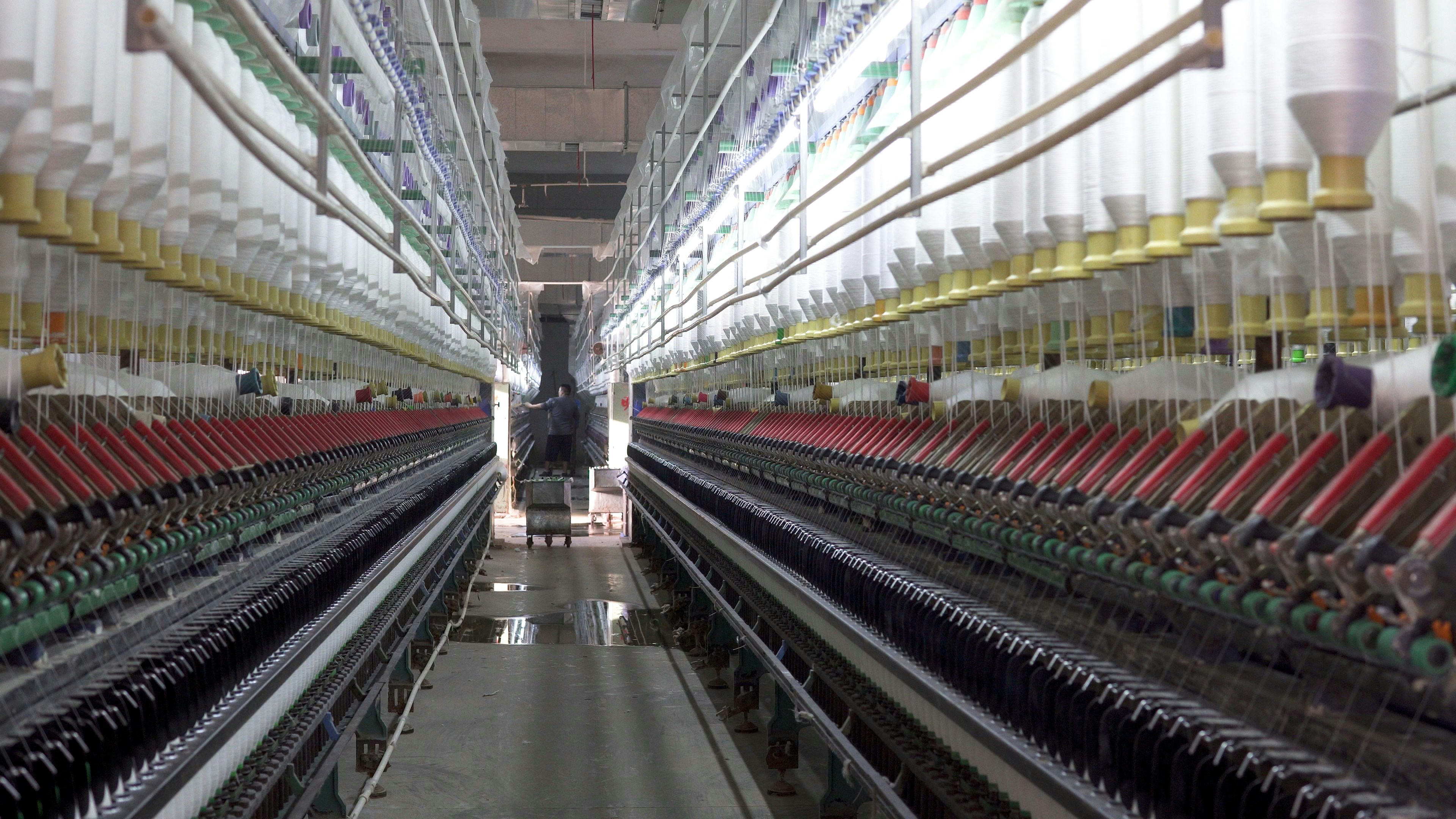 Scalable Bulk Production in an Overseas Garment Factory A large, modern garment factory with rows of sewing machines and workers.