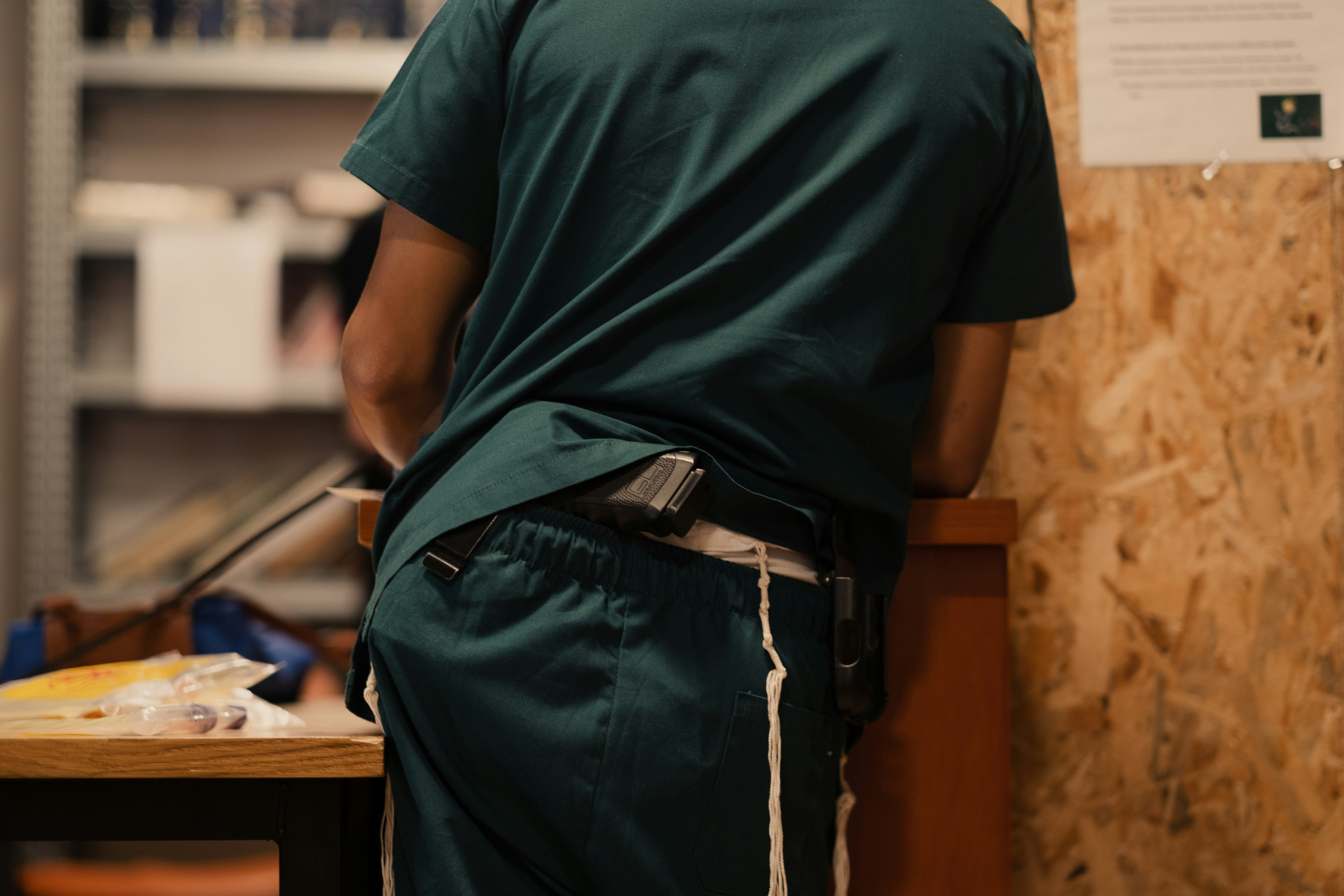 A quality control inspector examining the seams of a men's gym shirt.