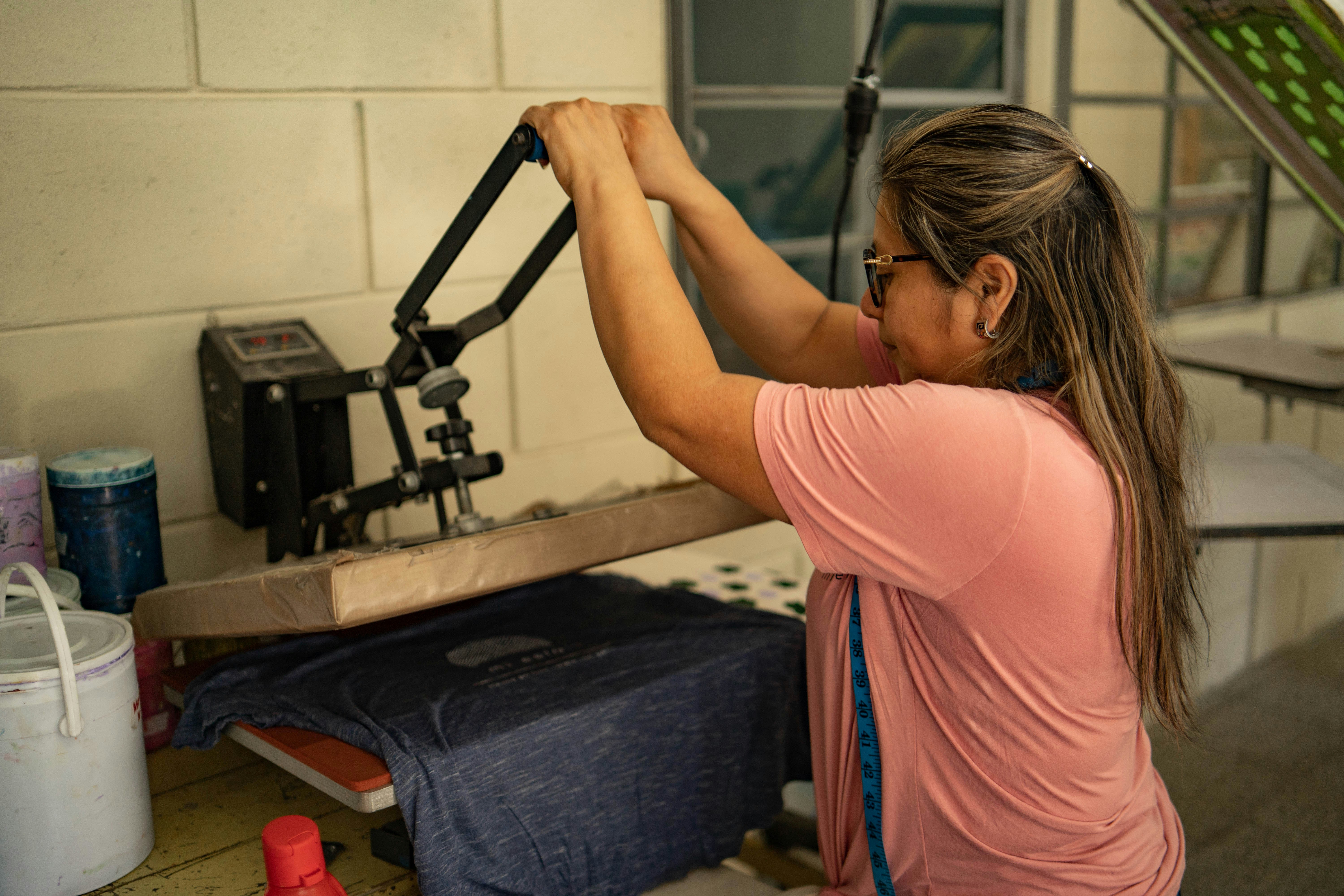 A factory worker meticulously inspecting a finished yoga bra