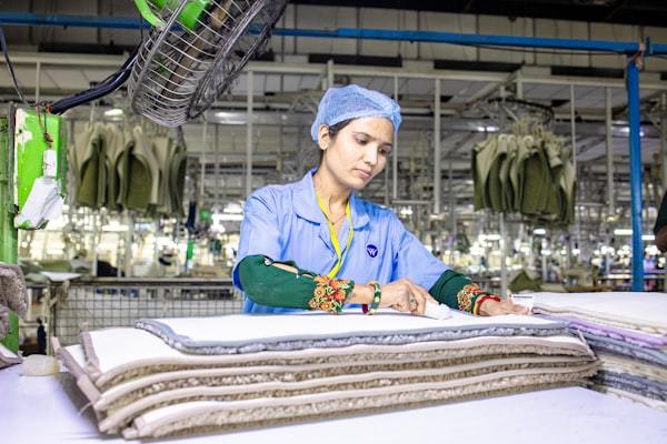 Skilled workers inspecting sportswear fabrics in factory