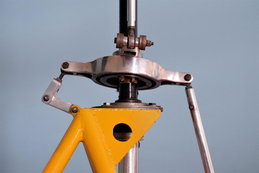 Close-up of a robust electric dirt bike frame and swingarm pivot point.