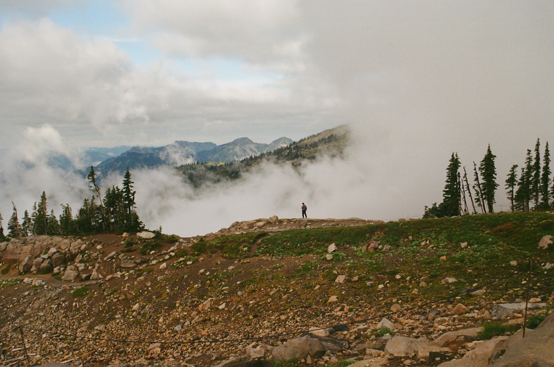 An electric dirt bike on a rocky trail with mountains in the background.
