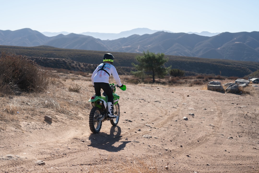 A rider on an electric dirt bike on a designated off-road trail