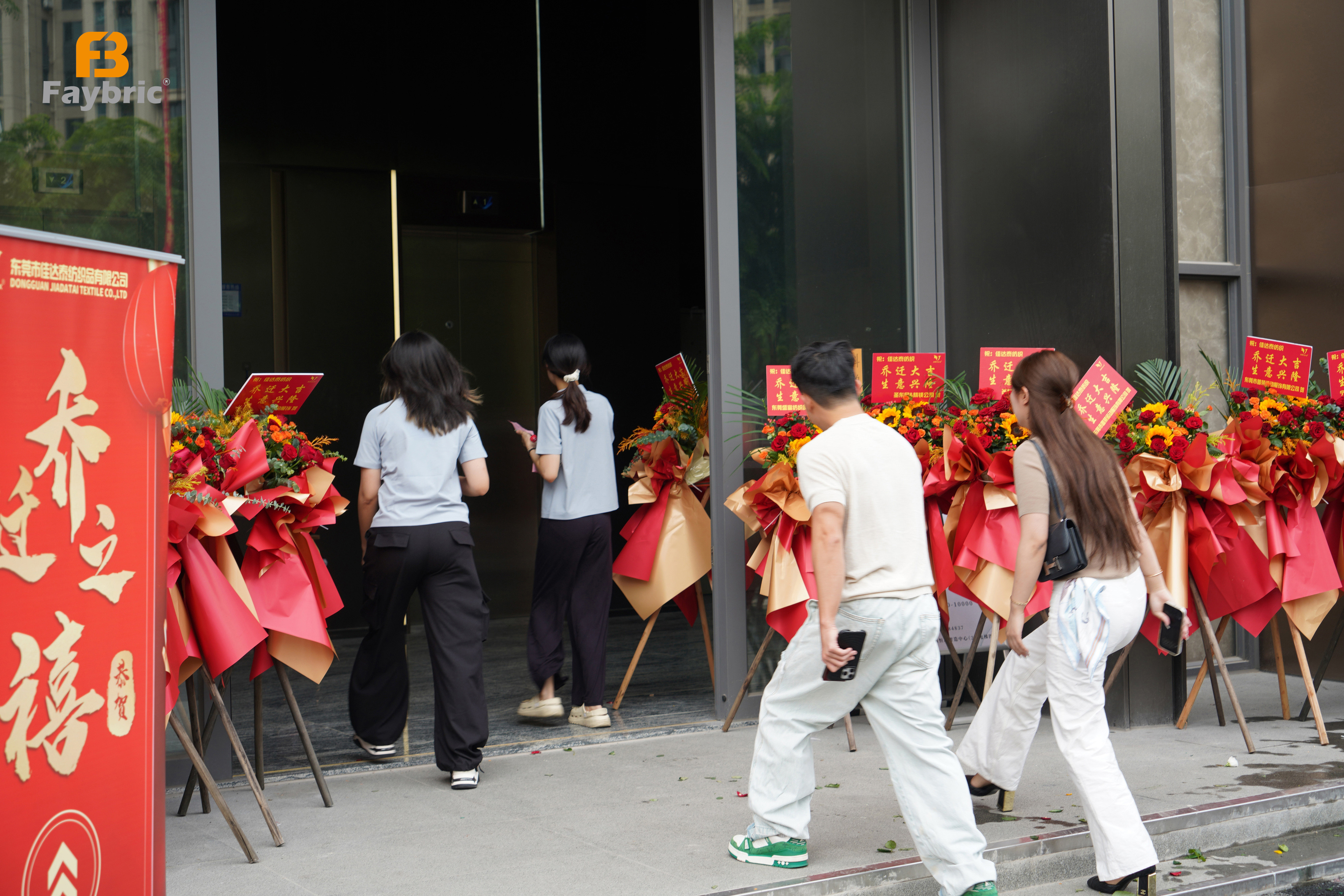 Faybric & Jdttex new office entrance decorated with congratulatory flower bouquets for relocation celebration