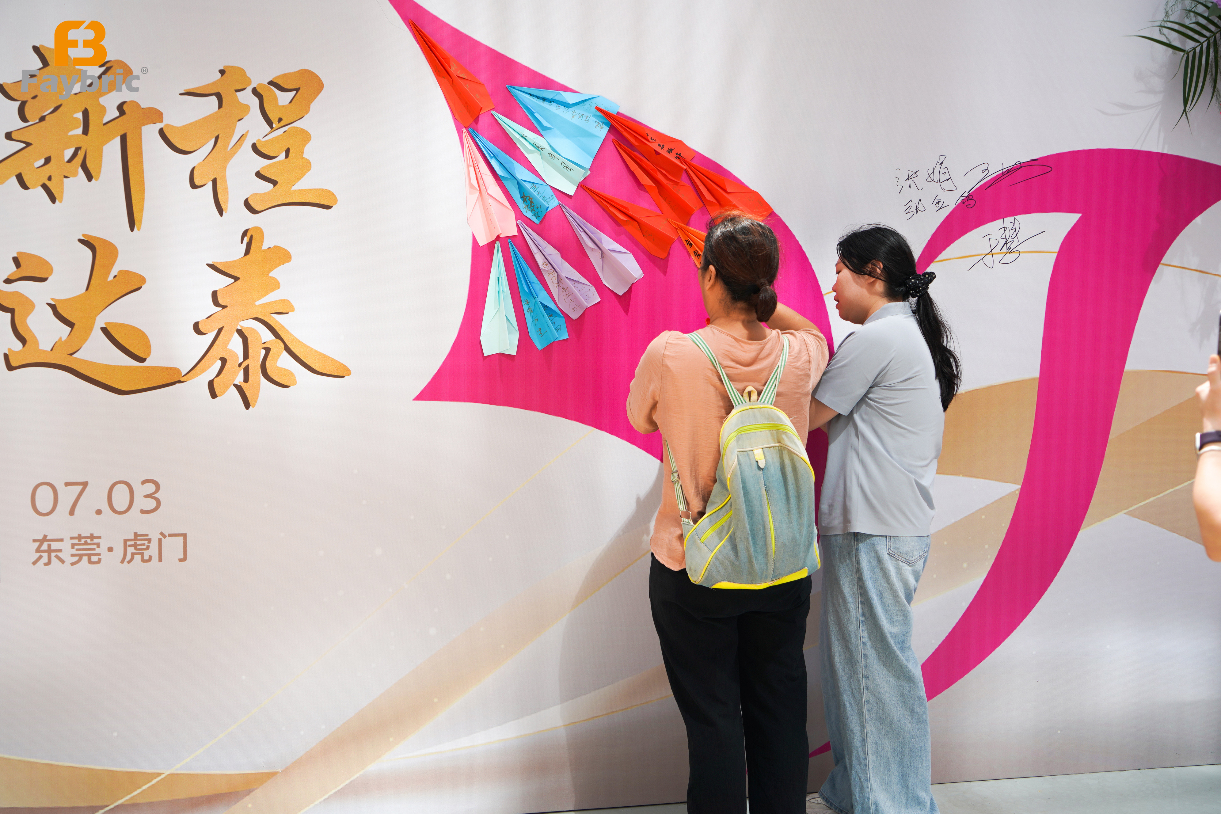 Guests signing on themed backdrop at Faybric Jdttex relocation event in Humen, Dongguan