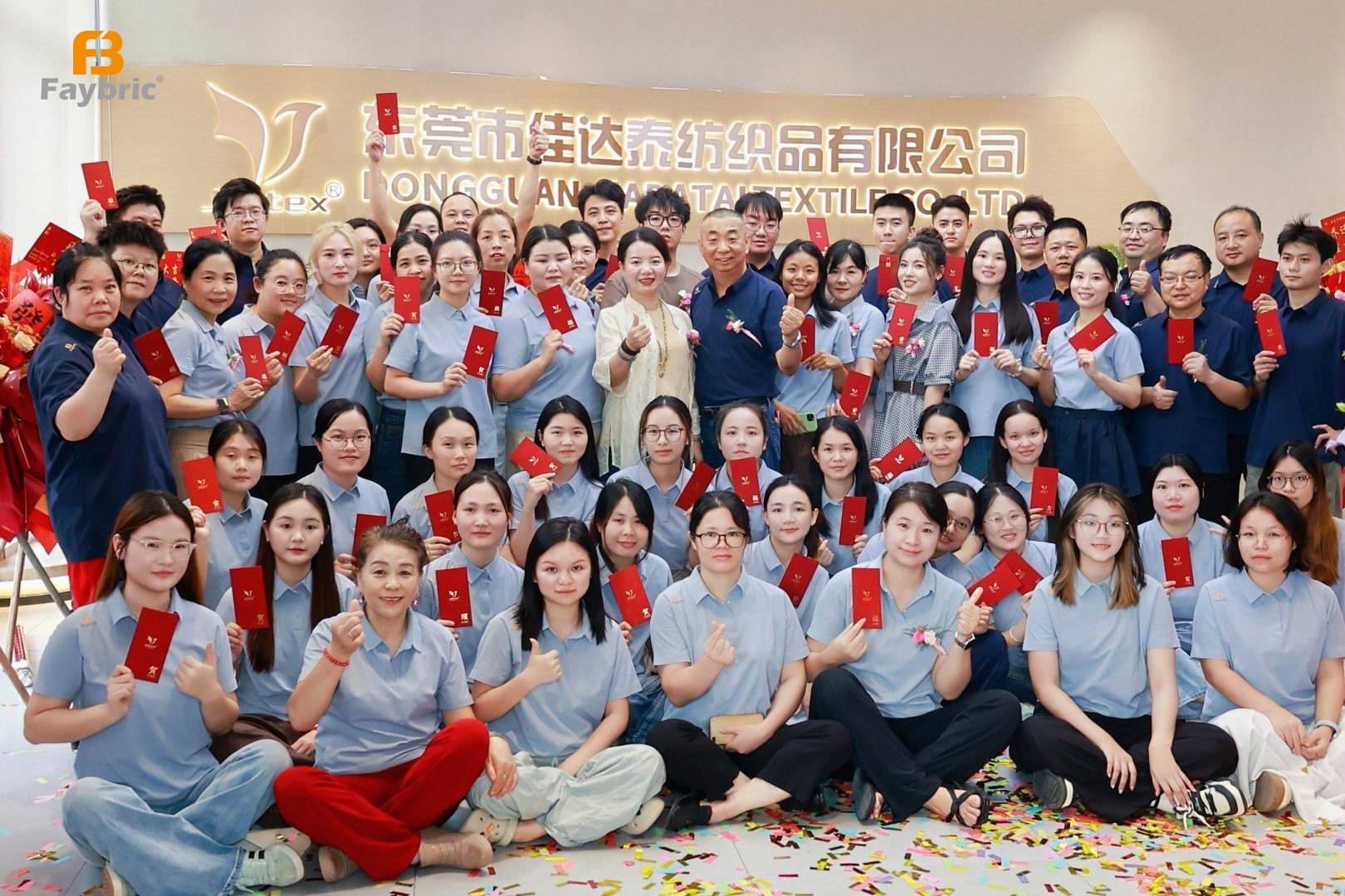 Faybric Jdttex whole team group photo holding red envelopes at the new office relocation celebration
