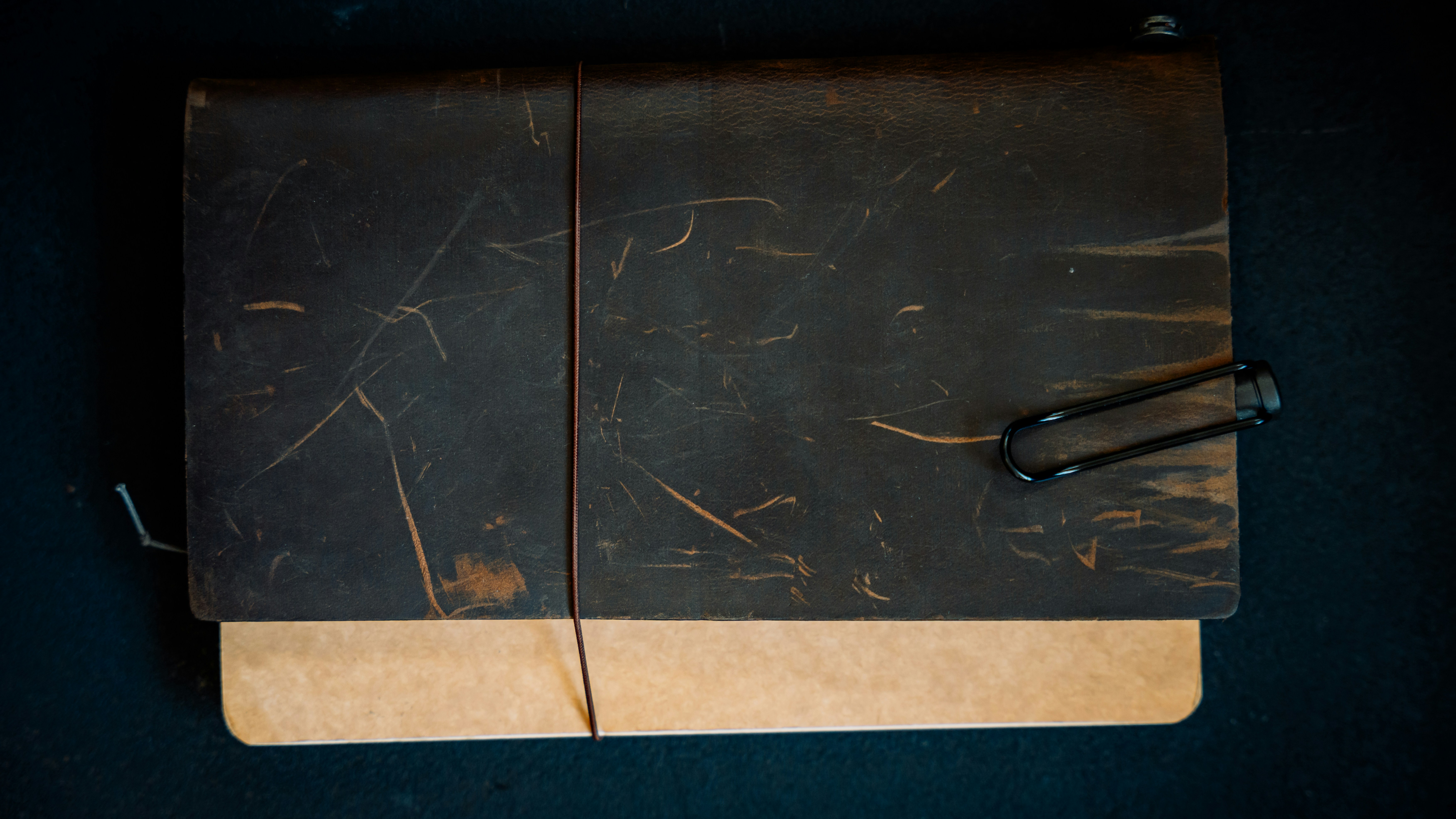 A severely warped and cracked black plastic cutting board, illustrating heat damage.