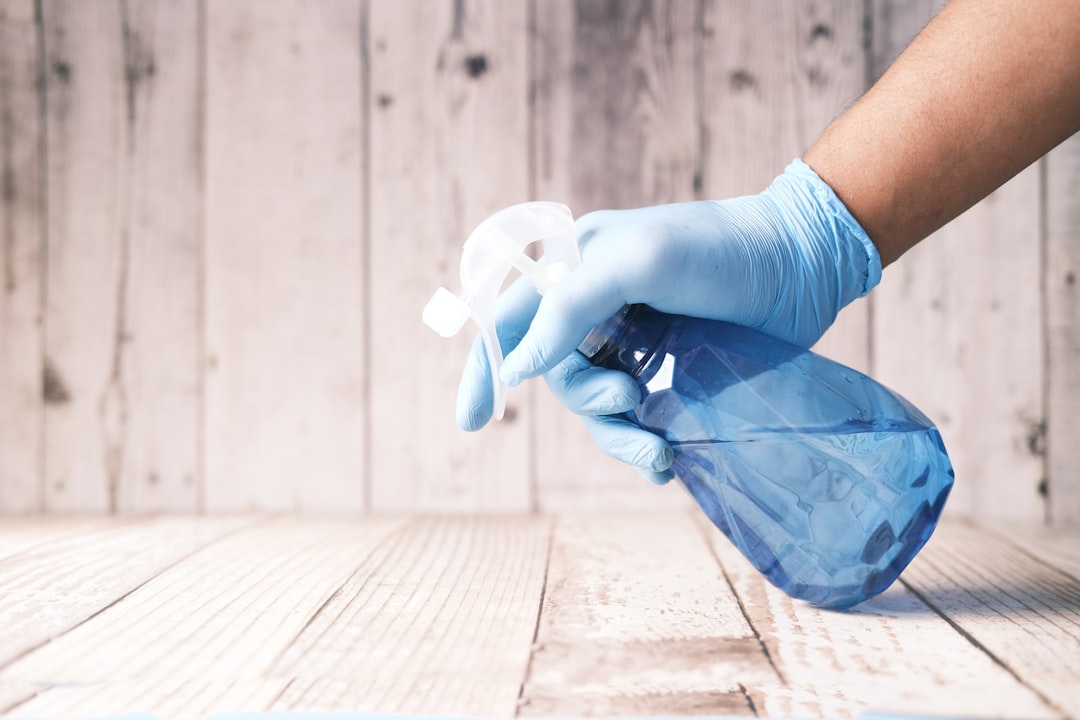 Cleaning supplies including a spray bottle with vinegar, baking soda, and a brush next to a plastic chopping board
