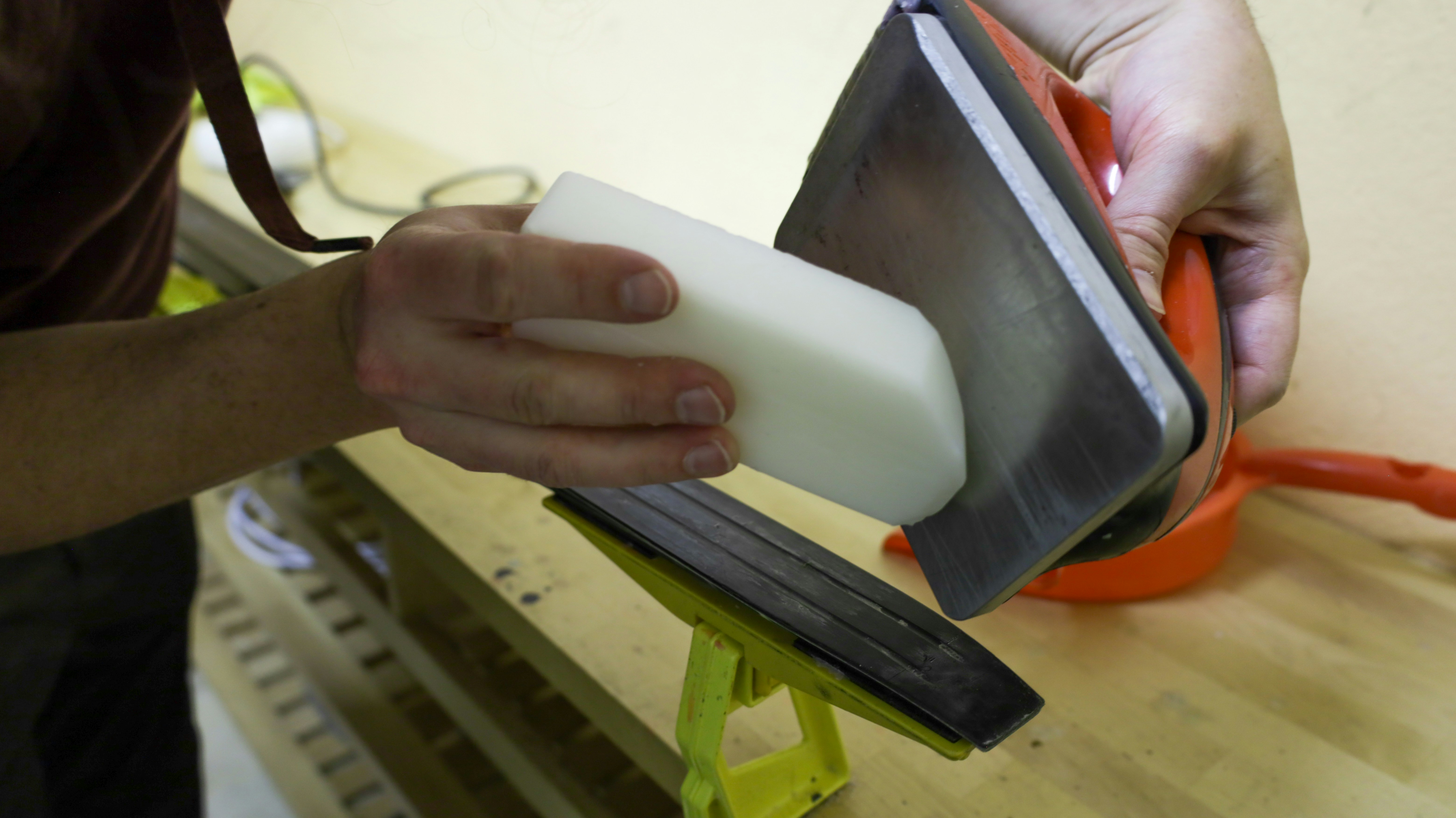 Easy cleaning of a non-porous HDPE cutting board A person easily wiping a white plastic cutting board clean with a sponge