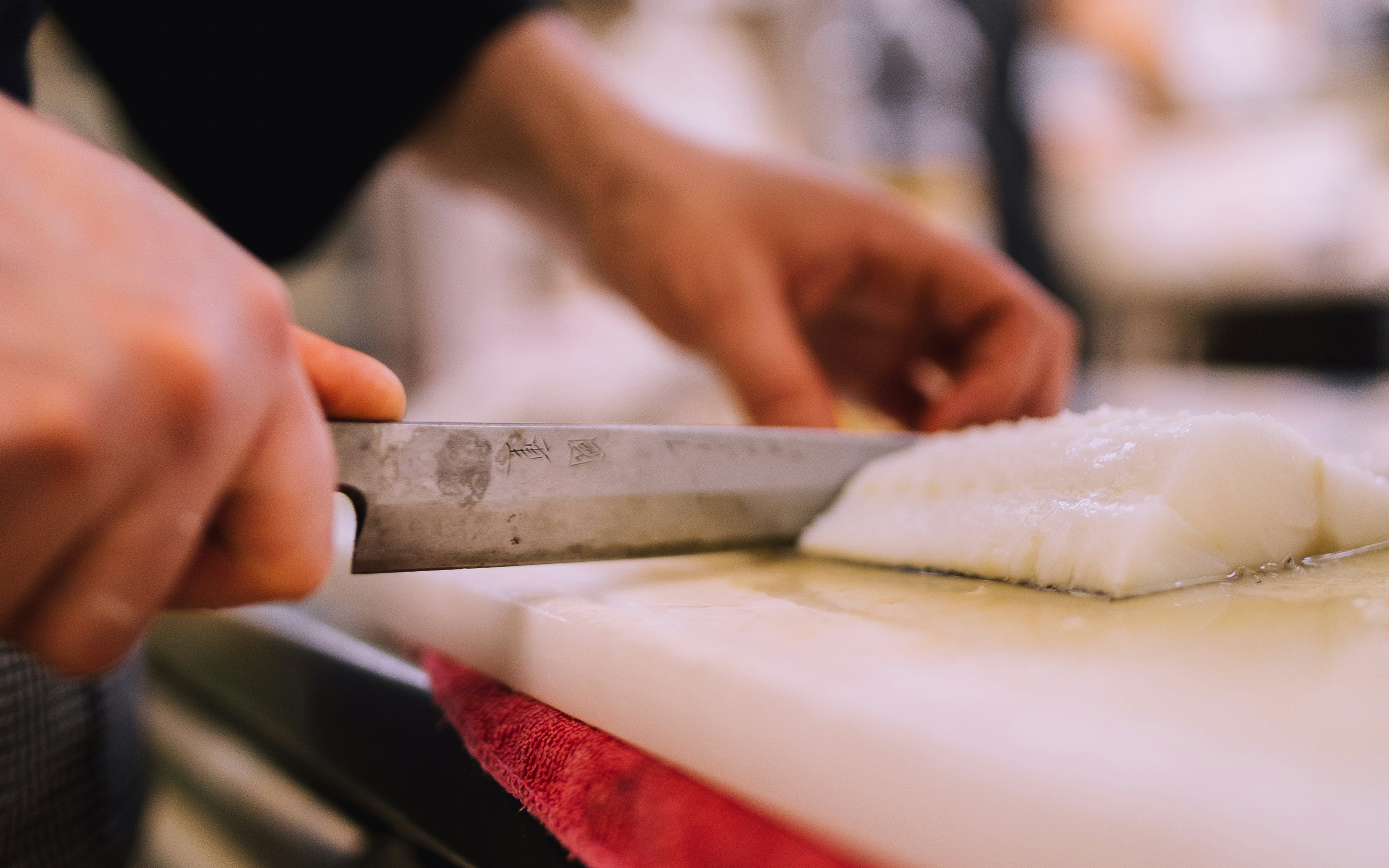 Hygienic White HDPE Cutting Board A clean, white HDPE plastic cutting board next to a chef's knife.