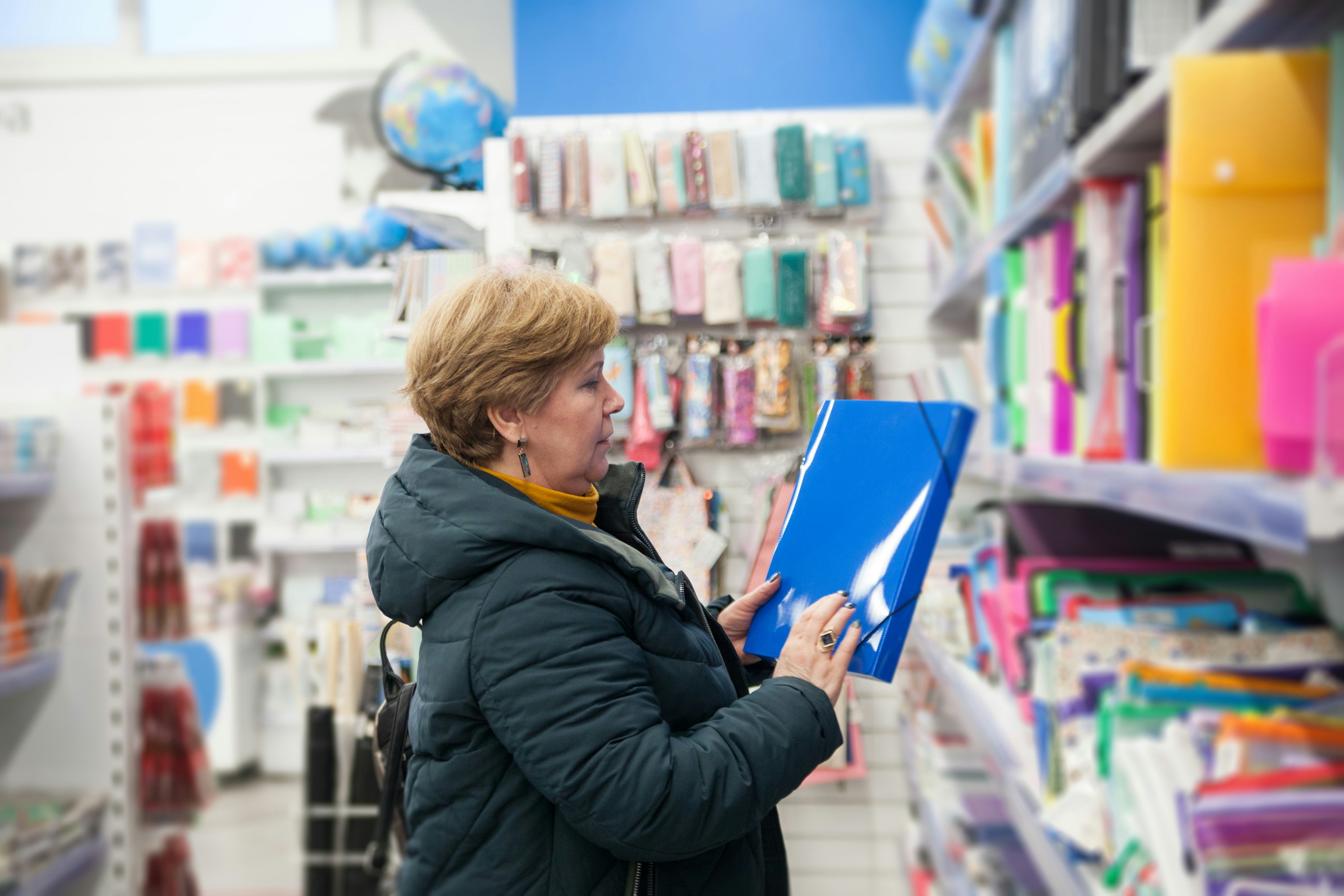 A person inspecting a TPU cutting board in a store, pointing to its features like non-slip edges and a smooth surface.