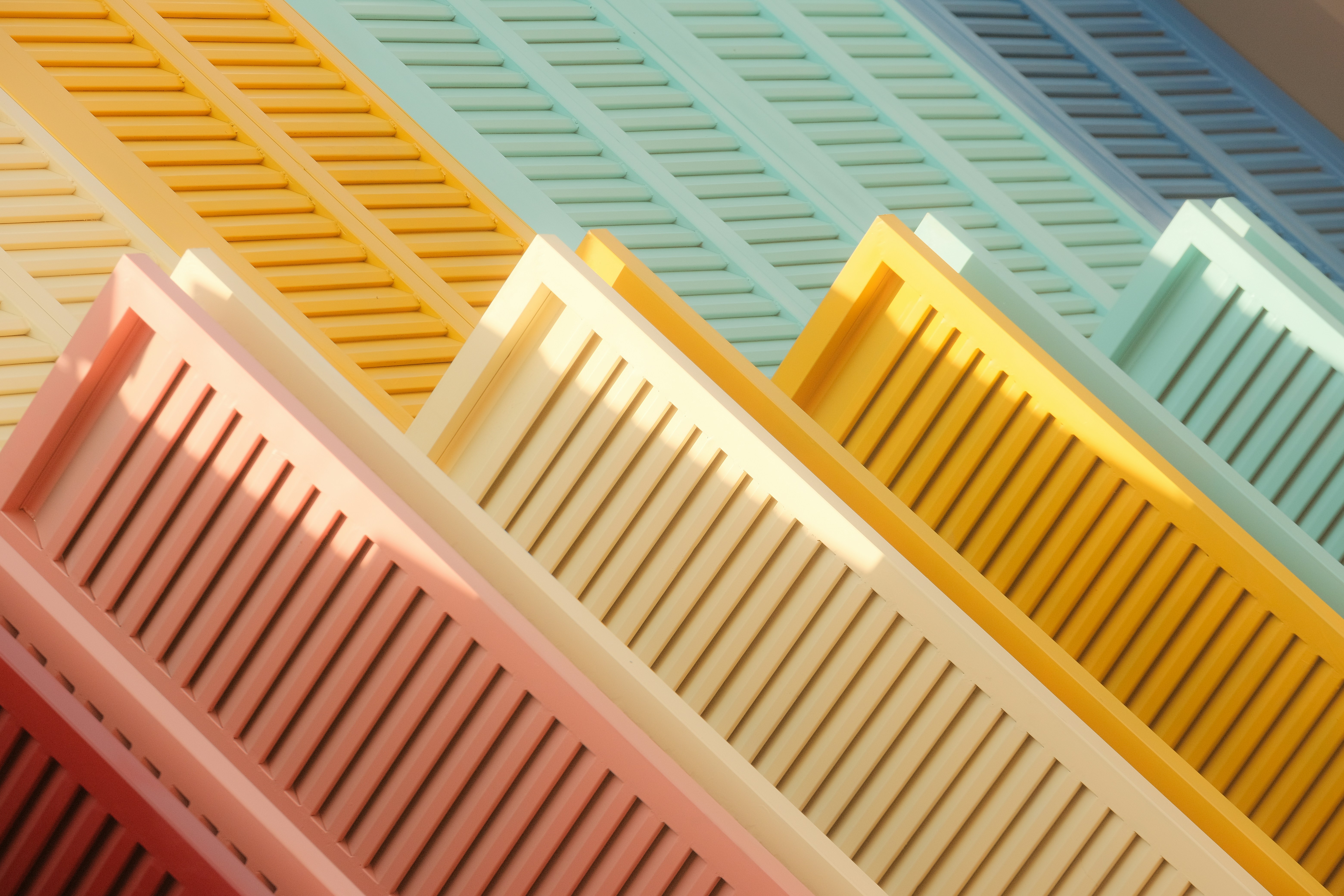 A set of three colorful plastic cutting boards being placed in a dishwasher
