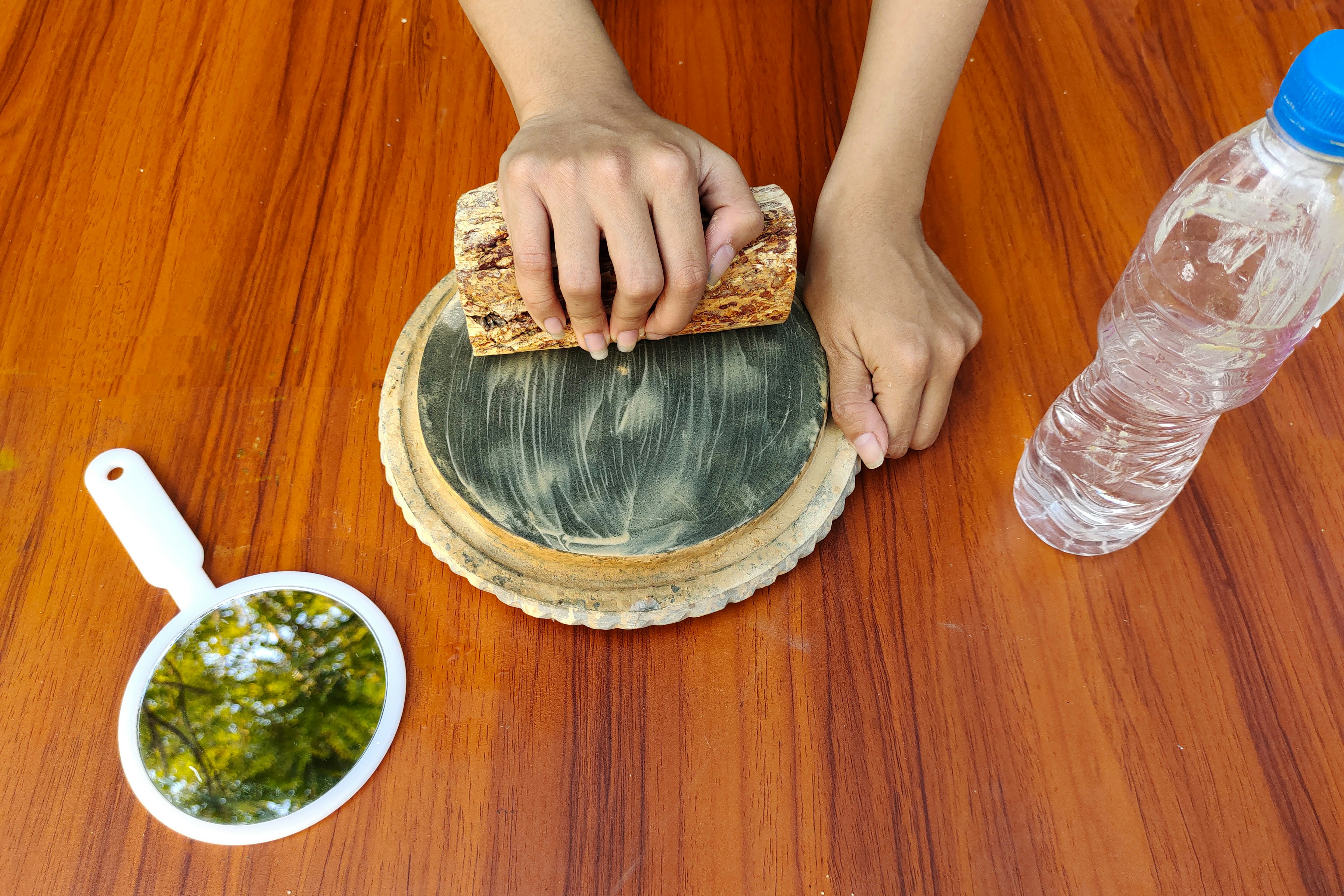 A person oiling a wooden cutting board with a cloth