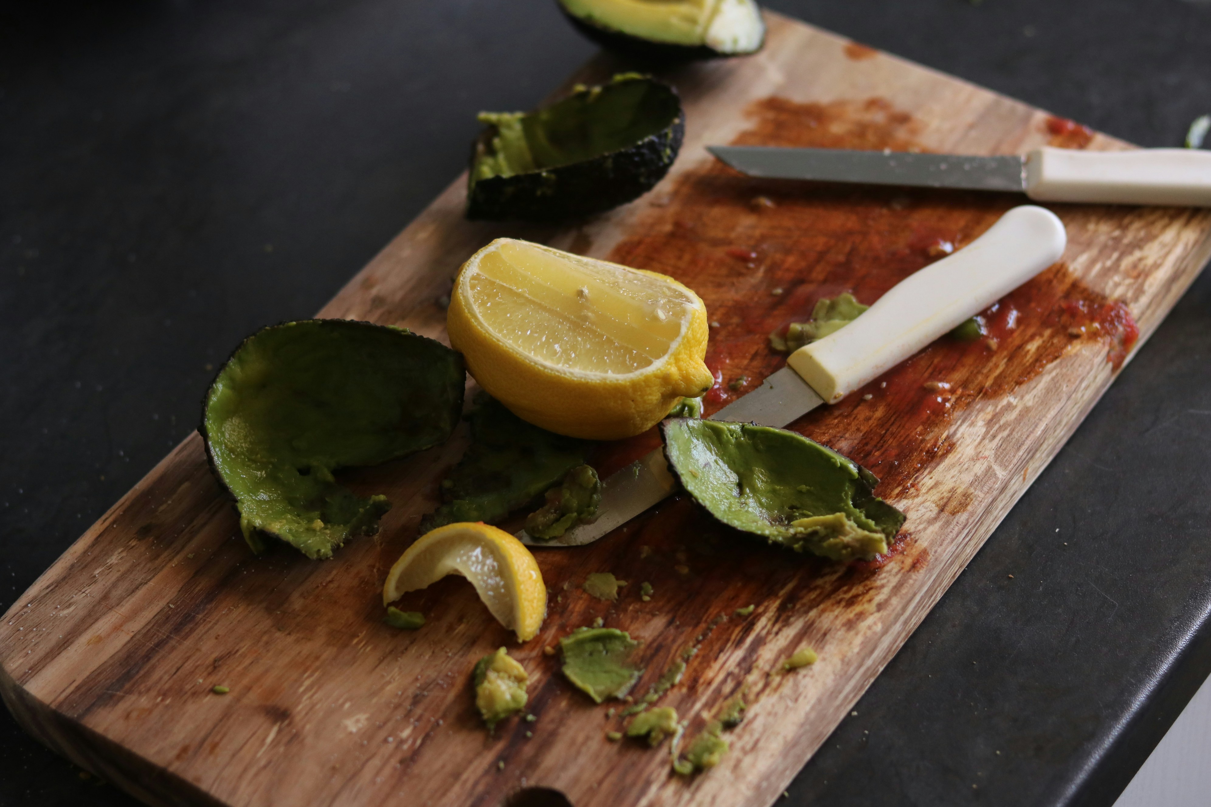 A cutting board stabilized on a countertop with a damp cloth underneath.