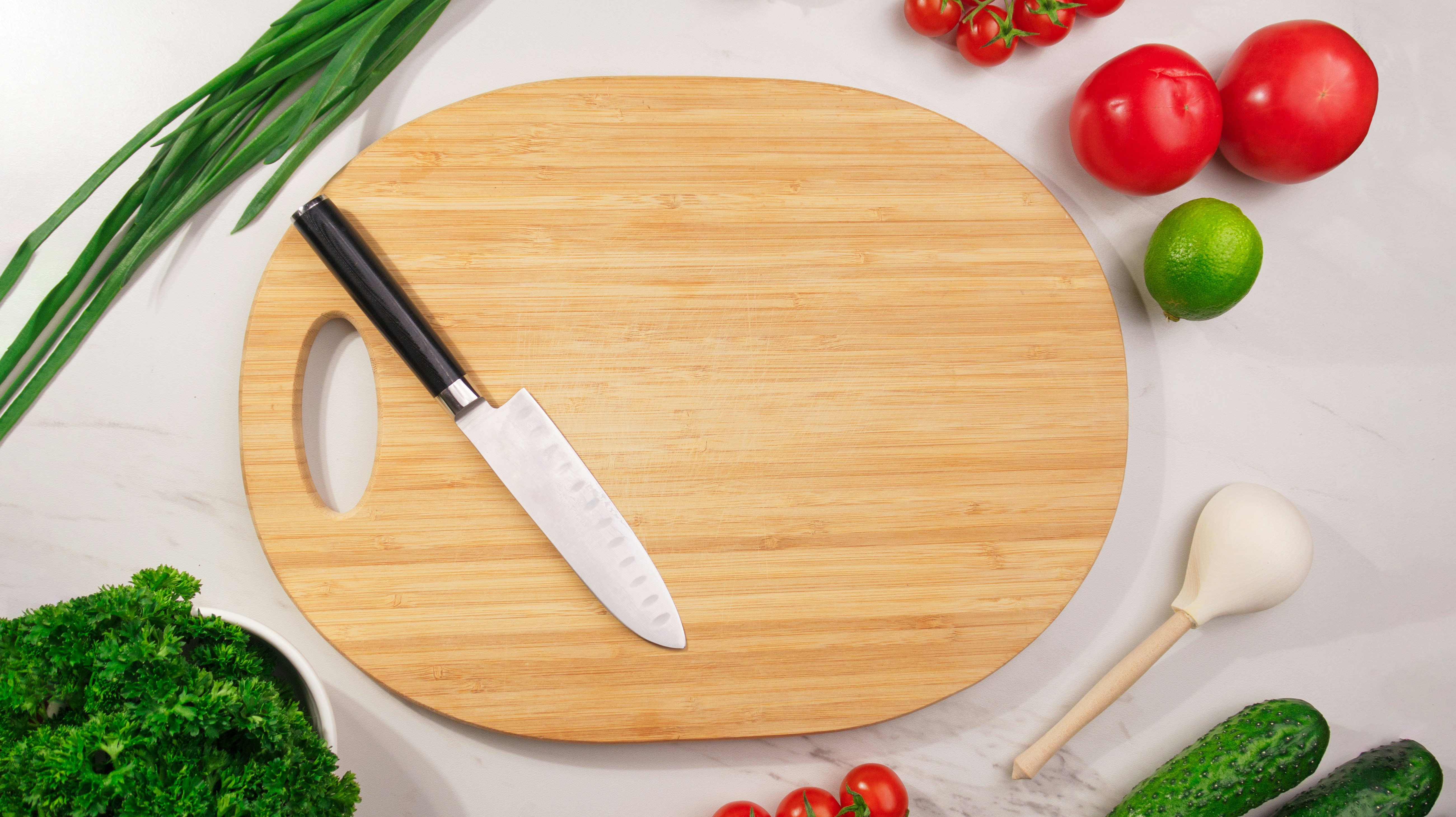 a wheat straw cutting board with fresh vegetables on it in a bright kitchen