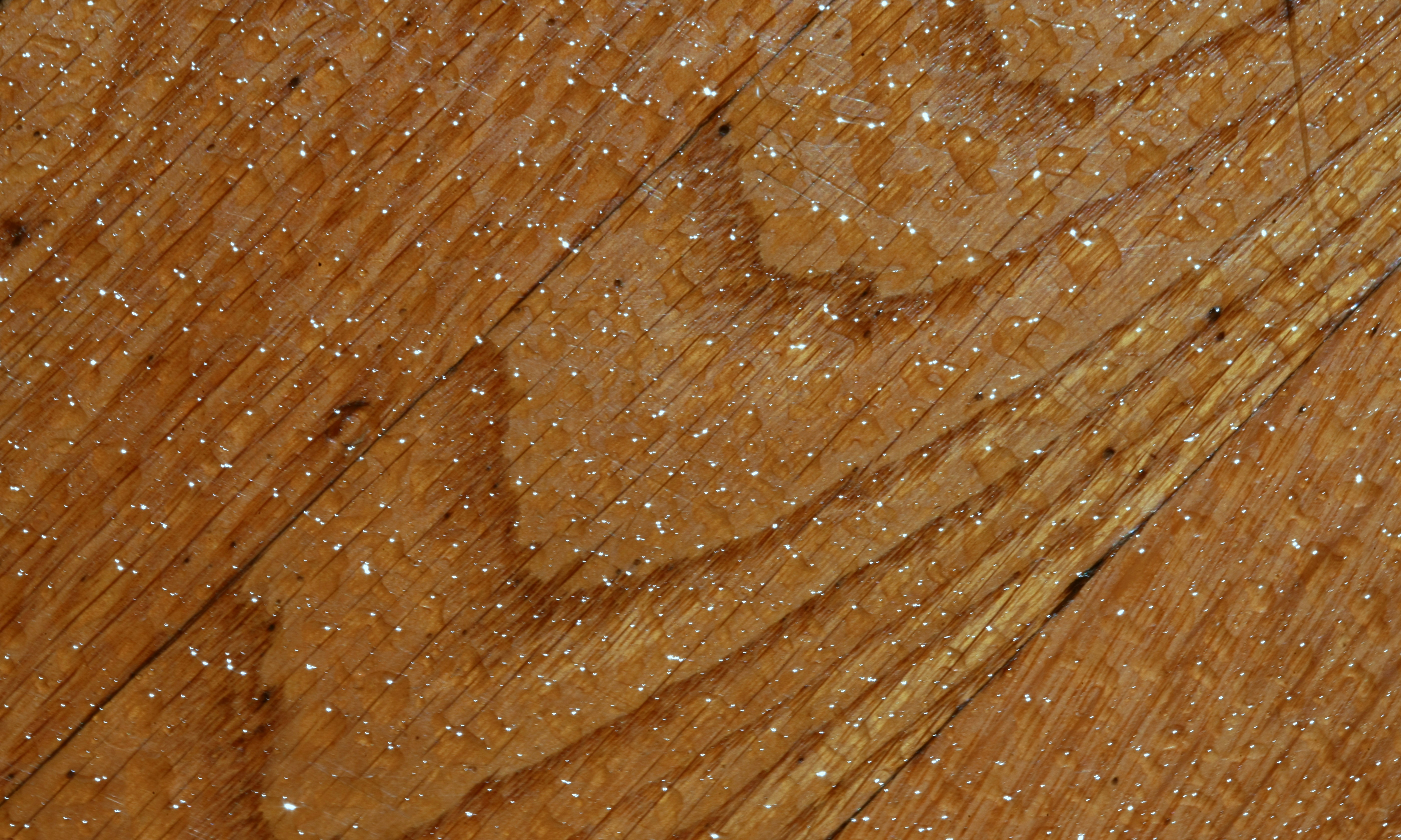 A close-up view of water beading on the non-porous surface of a plastic cutting board, demonstrating its hygienic properties.
