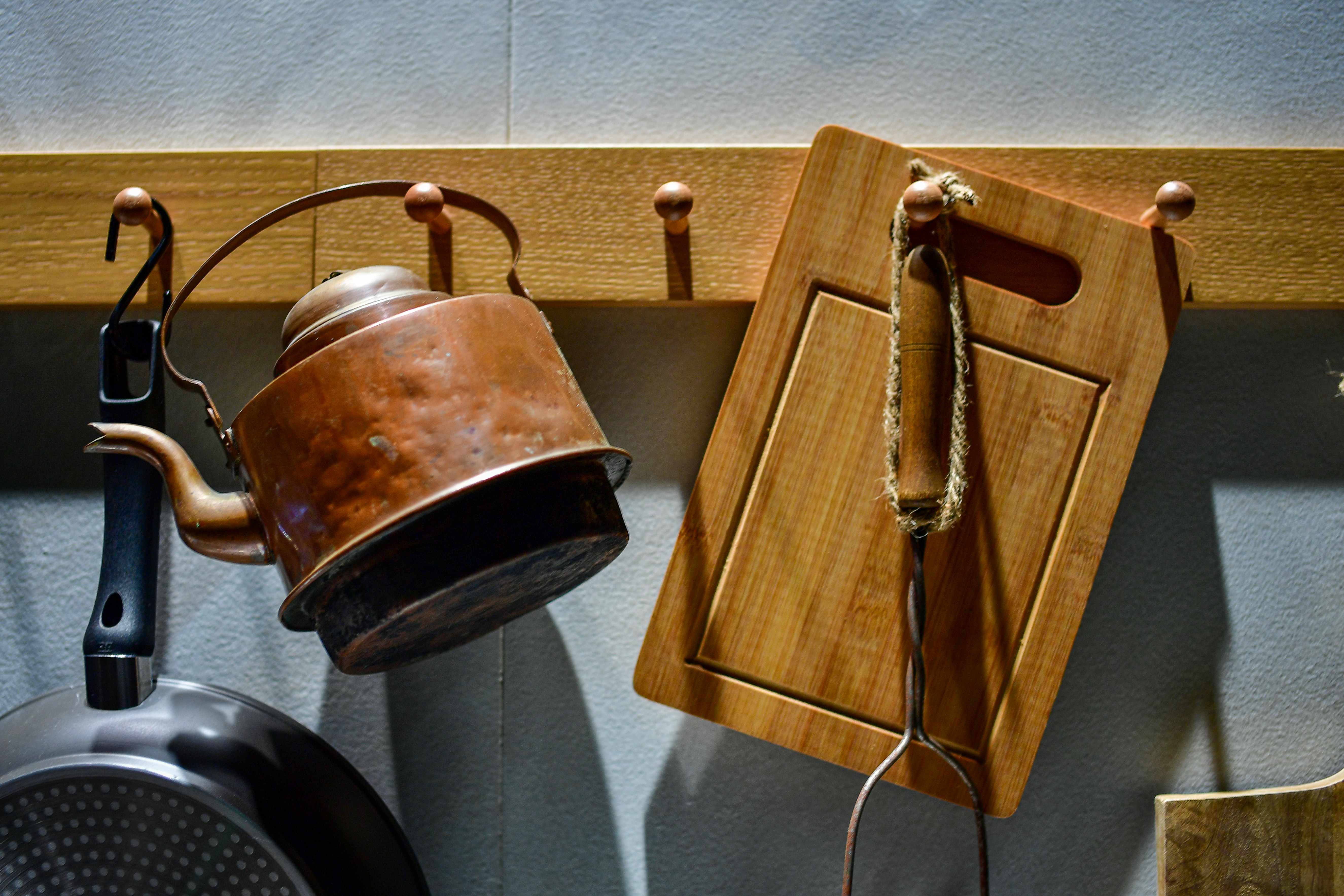 A clean plastic cutting board stored vertically in a kitchen rack to air dry.