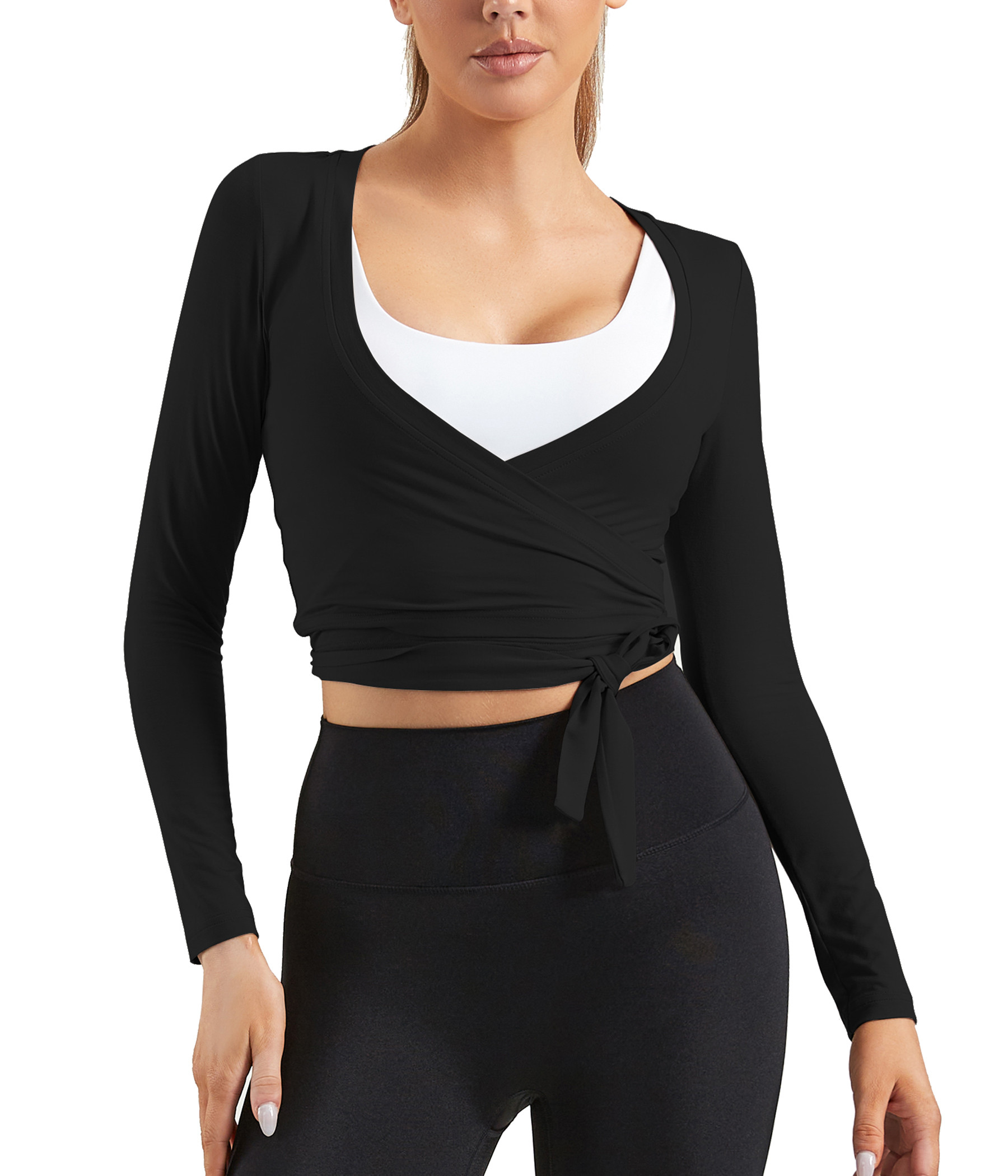 Wrap-front black crop top layered over white sports bra