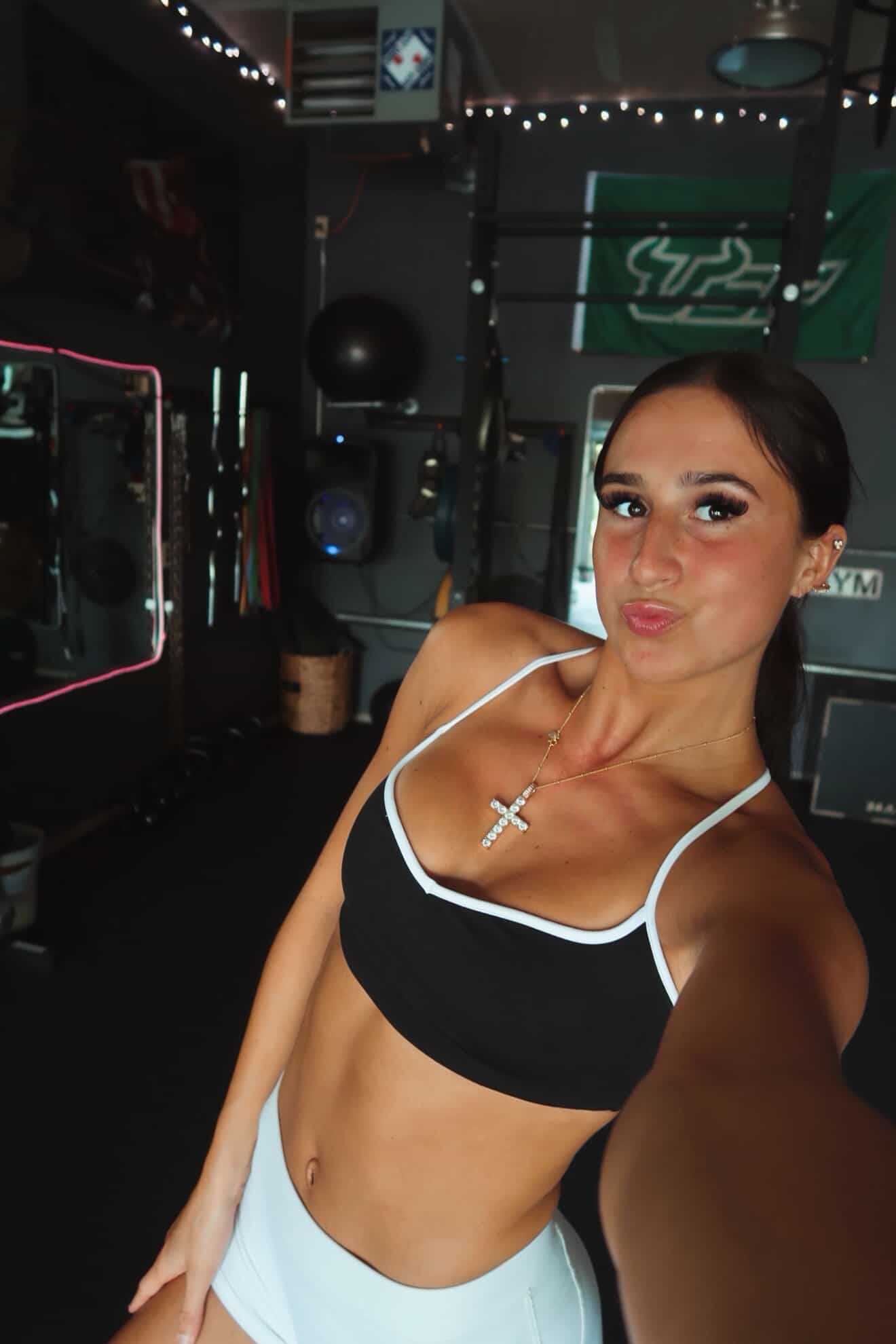 Gym selfie in black-and-white sports bra with white shorts, athleisure