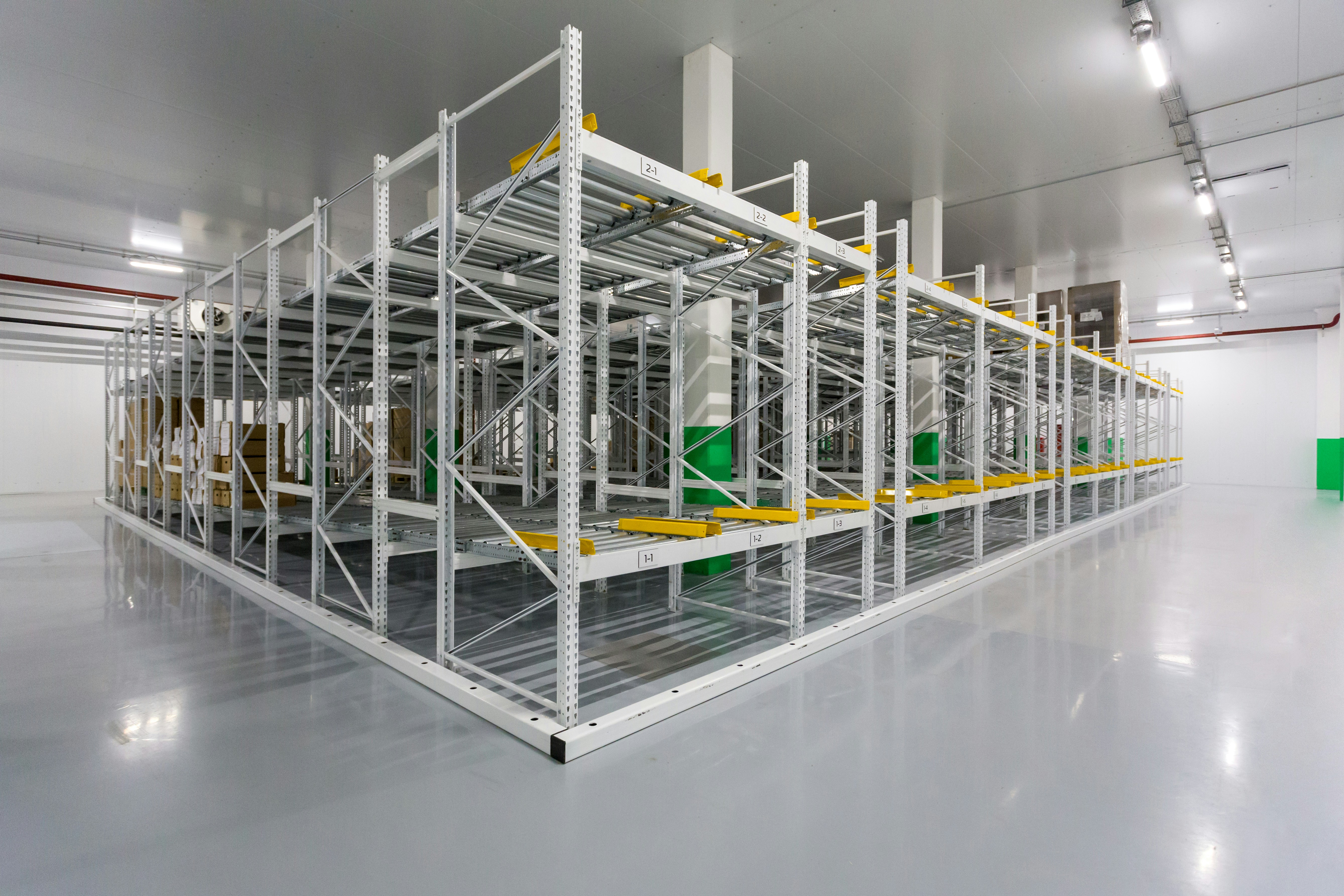 A flexible roller conveyor connected to a larger, fixed conveyor system inside a warehouse.