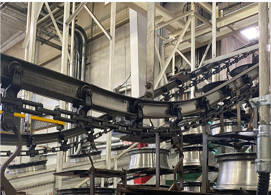 What are the advantages of overhead conveyor systems in the assembly line?