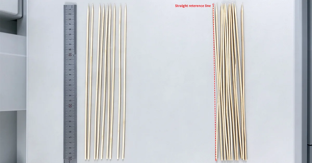 Straight and visibly bent bamboo skewers compared side by side on a flat reference surface