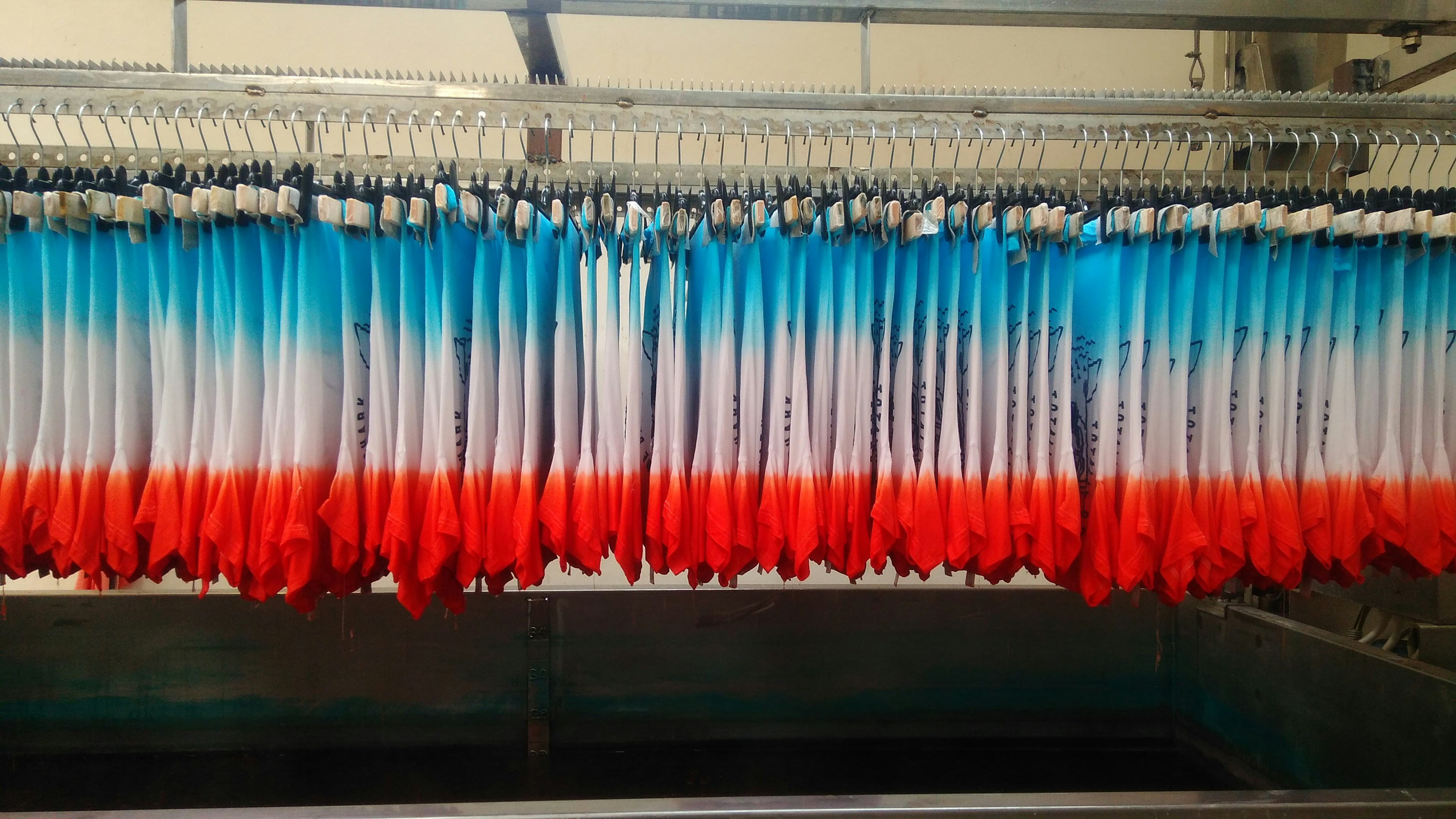 A detailed view of a pre-production sample garment being inspected for stitch quality and fabric texture.