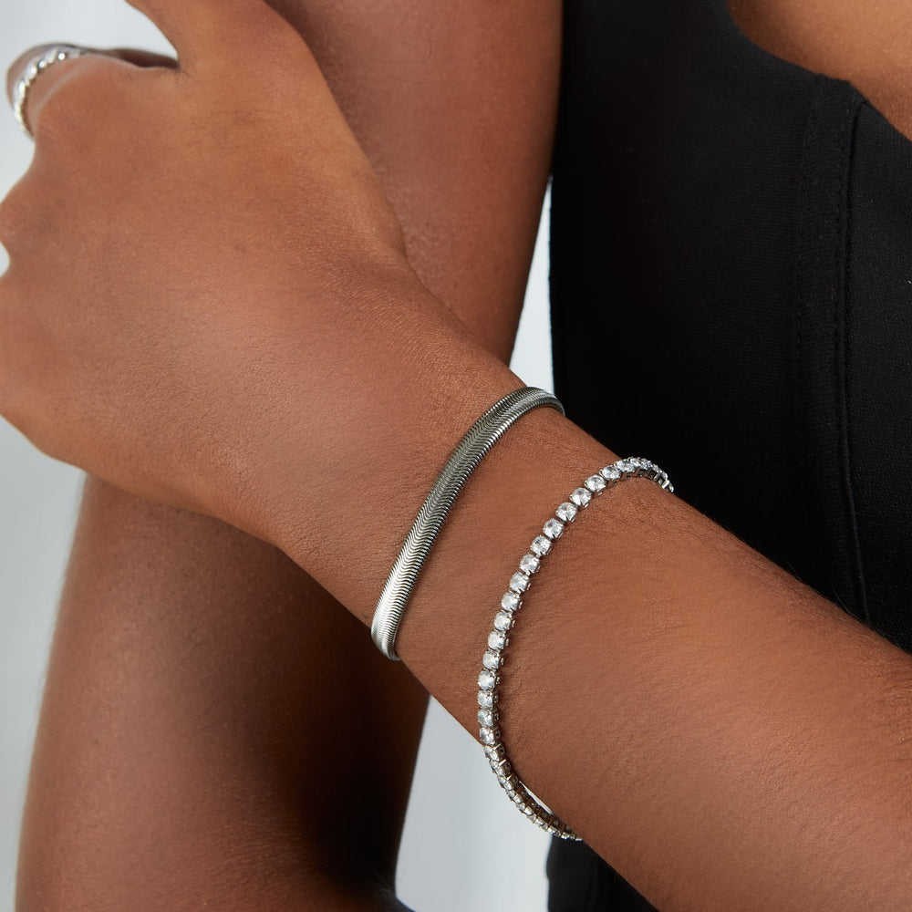 Silver tennis bracelet arranged in a horizontal product scene
