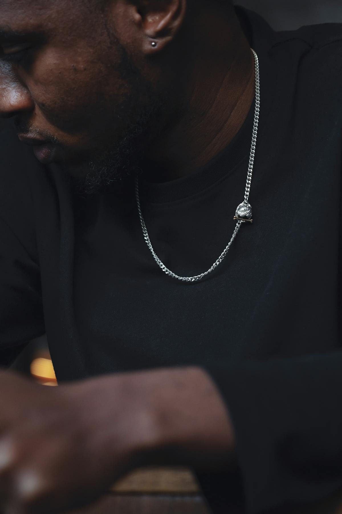 Man wearing a silver Cuban link chain with a black shirt