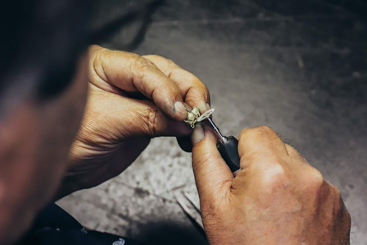 Jeweler polishing a silver jewelry piece with a precision tool