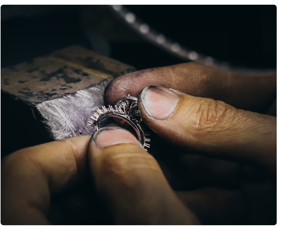 Jewelry artisan refining a silver jewelry ring during precision assembly