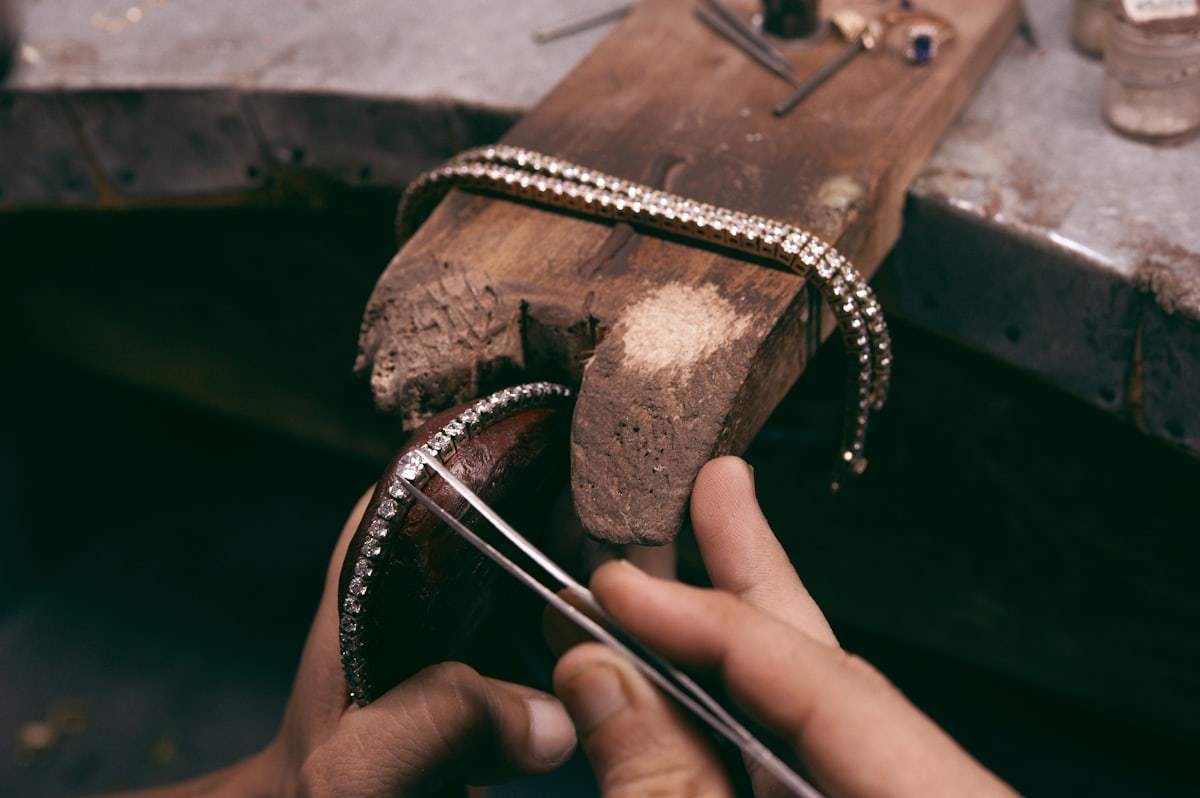 Jeweler inspecting a silver jewelry bracelet with precision tools
