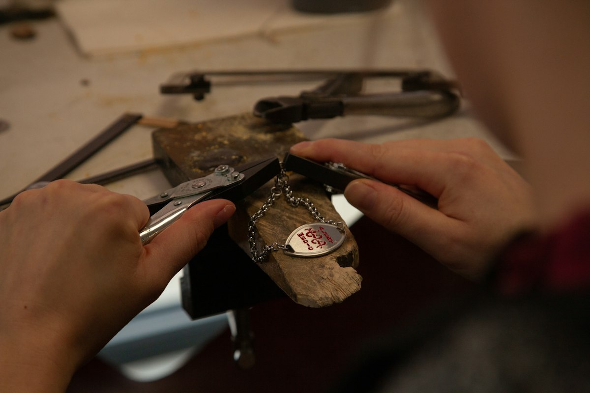 Jewelry maker working on a sample with hand tools