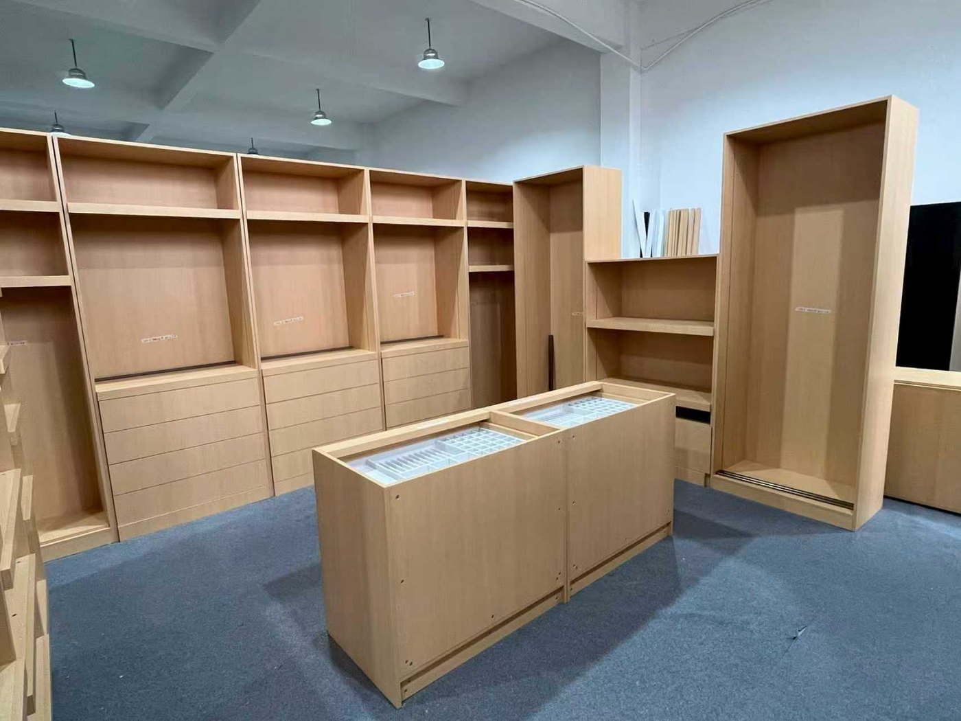 Full set of natural wood custom cabinetry — wall units, drawer banks and a tall wardrobe — assembled and standing square