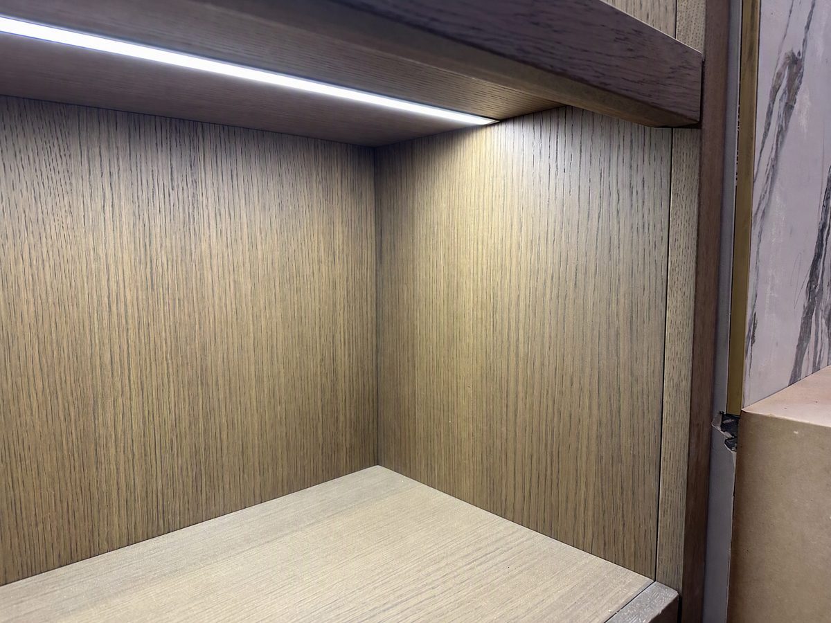 Cabinet interior detail showing wood veneer and integrated LED lighting