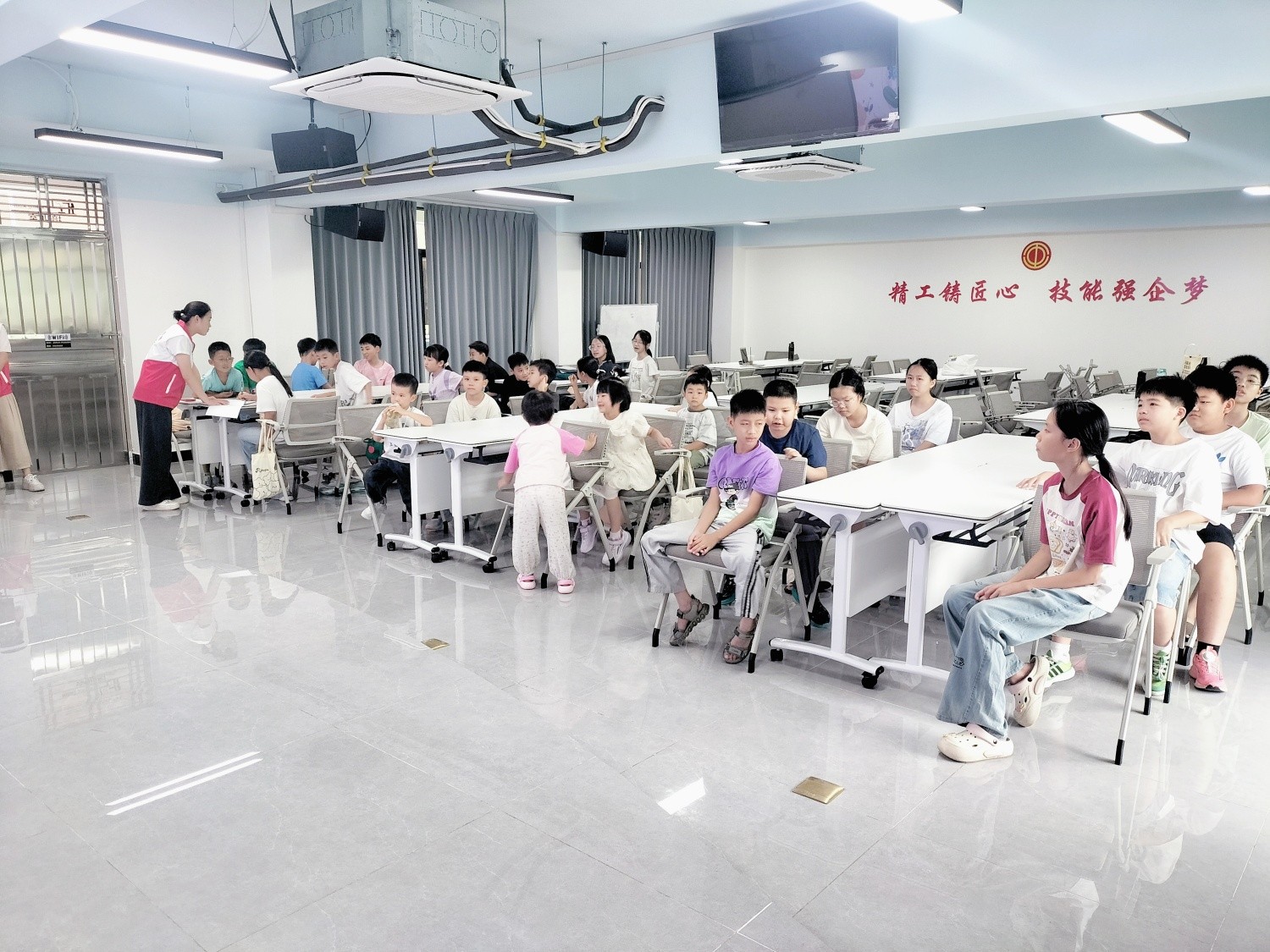 Figure 2: Volunteers and children take part in interactive learning in the KeyPadOne training room, demonstrating the company's care and support for employees' families.