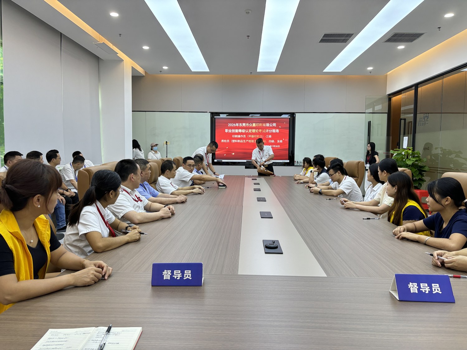 Figure 1: KeyPadOne vocational skill level certification written exam site - supervisors preside while candidates take the unified closed-book theory test, with exam information displayed on the large screen in real time.