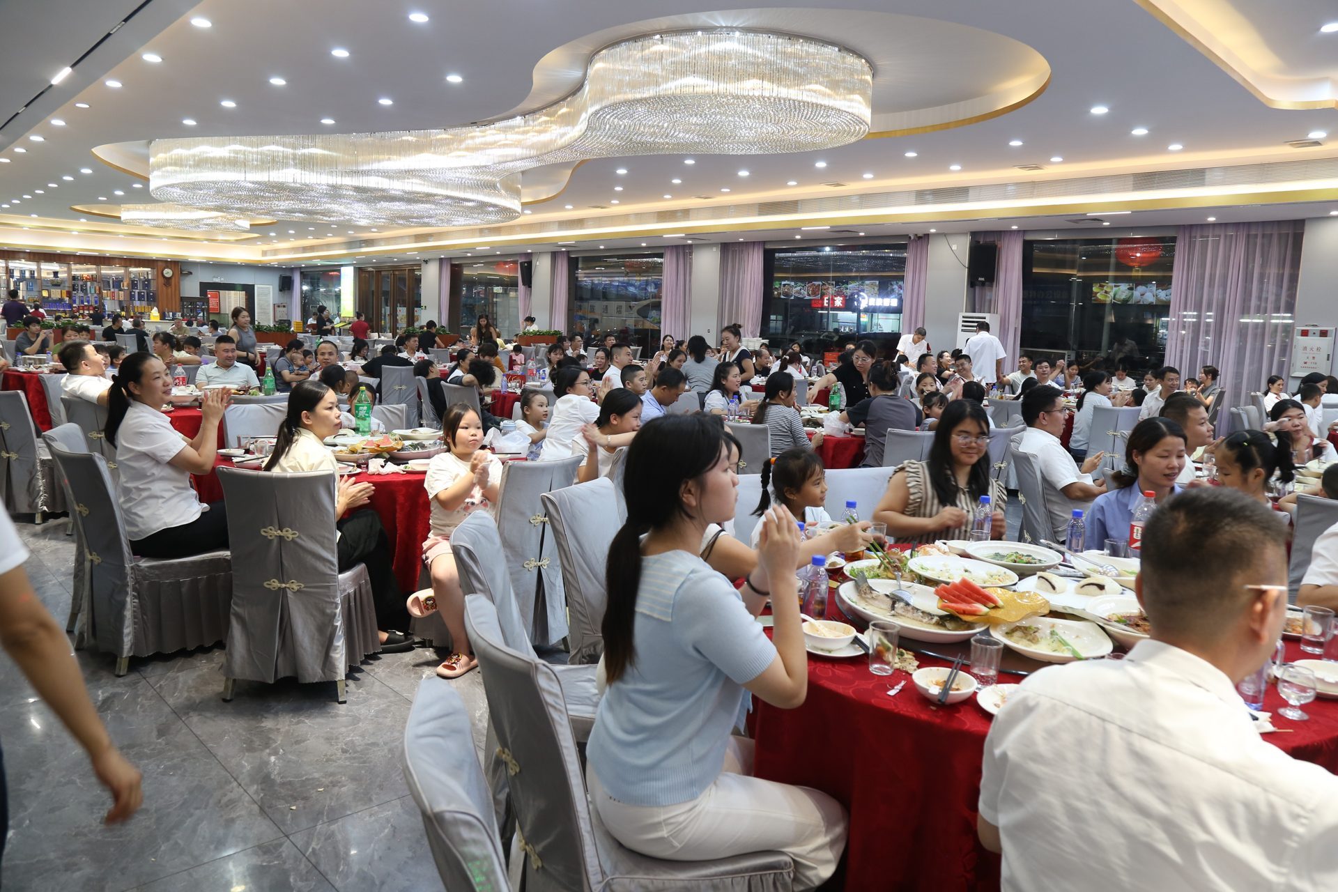 KeypadOne employees and their family members dine together at round banquet tables during the 2026 summer family appreciation banquet.