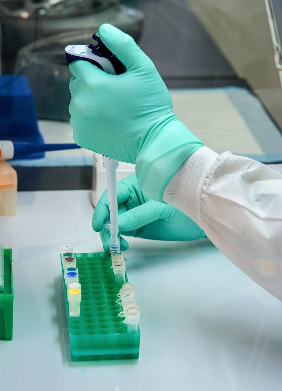 Technician in cleanroom garments handling optical components during medical-grade assembly and packaging