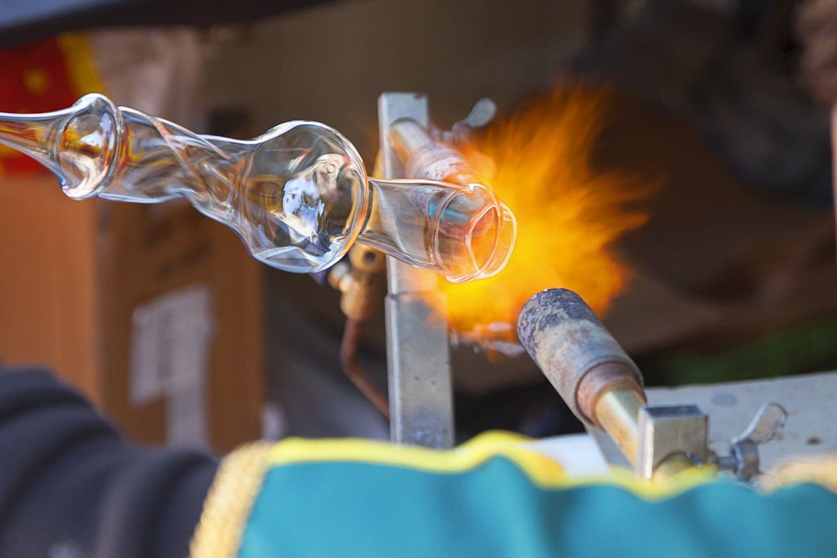 Industrial glass manufacturing process showing high-temperature glass forming for furnace viewport production