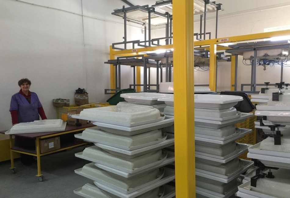 Formed acrylic bathtub and shower tray shells stacked in FOT factory ready for trimming