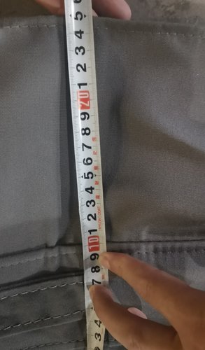 Measuring spa cover thickness with tape measure during quality inspection