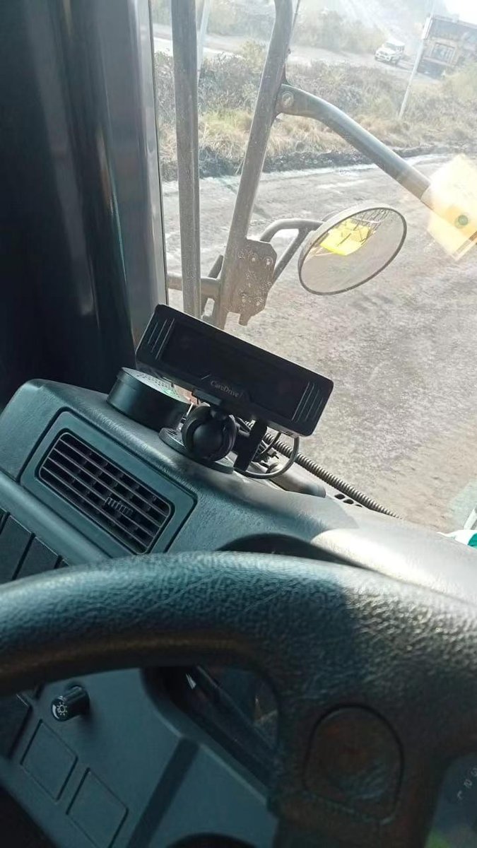 Driver monitoring device mounted on the dashboard of a truck