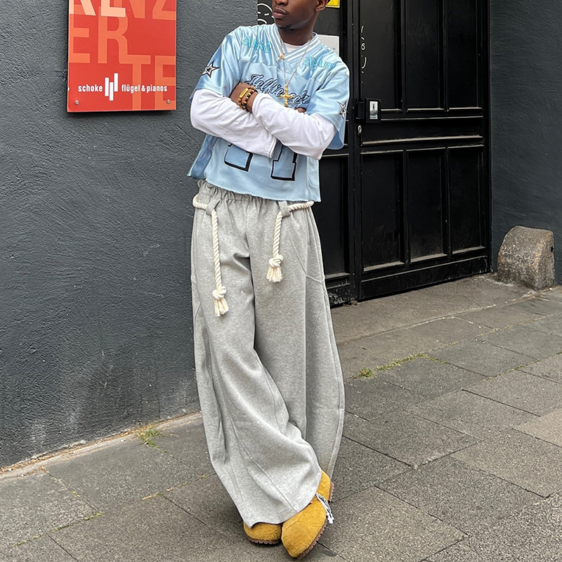 A streetwear designer in Los Angeles reviewing fabric swatches, choosing the perfect heavyweight cotton for a new oversized t-shirt collection.