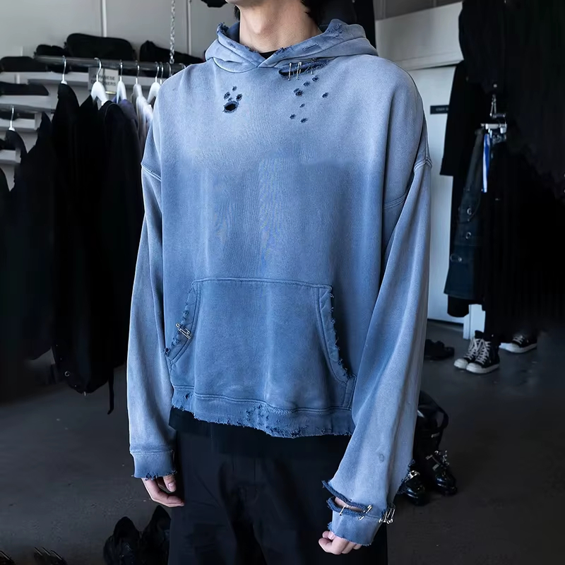 A high-end streetwear garment being meticulously inspected on a cutting table in a modern European clothing manufacturing facility.