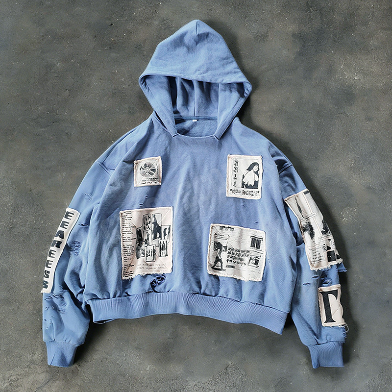 Distressed embroidery hoodie close-up showing vintage wash texture and detailed stitching from a Dongguan streetwear factory.