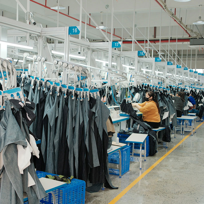 Quality control in streetwear manufacturing at Groovecolor production line in Dongguan China showing fabric inspection