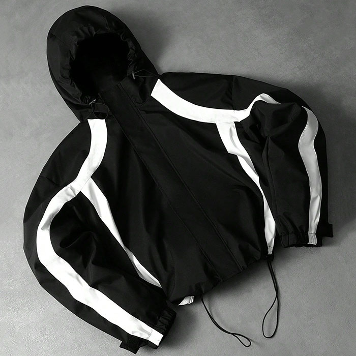 Cut-and-sew streetwear production table in Dongguan with patterns, fabric swatches, and QC sheets
