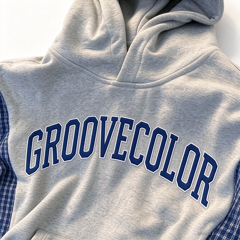 Side profile wearing view of custom contrast plaid‑sleeve spliced oversized hoodie sample