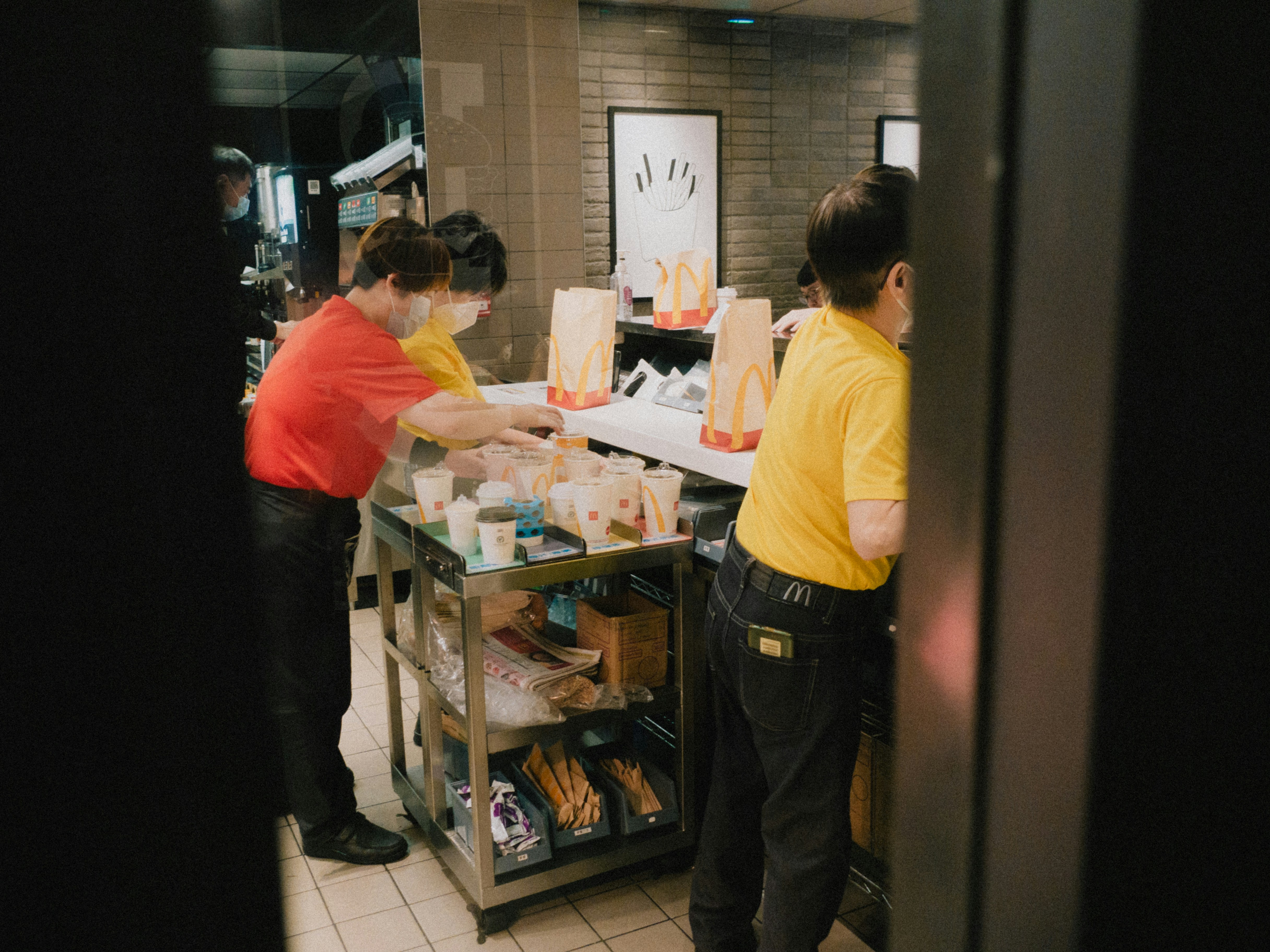 A kitchen employee wearing non-slip shoes and an apron in a clean commercial kitchen.